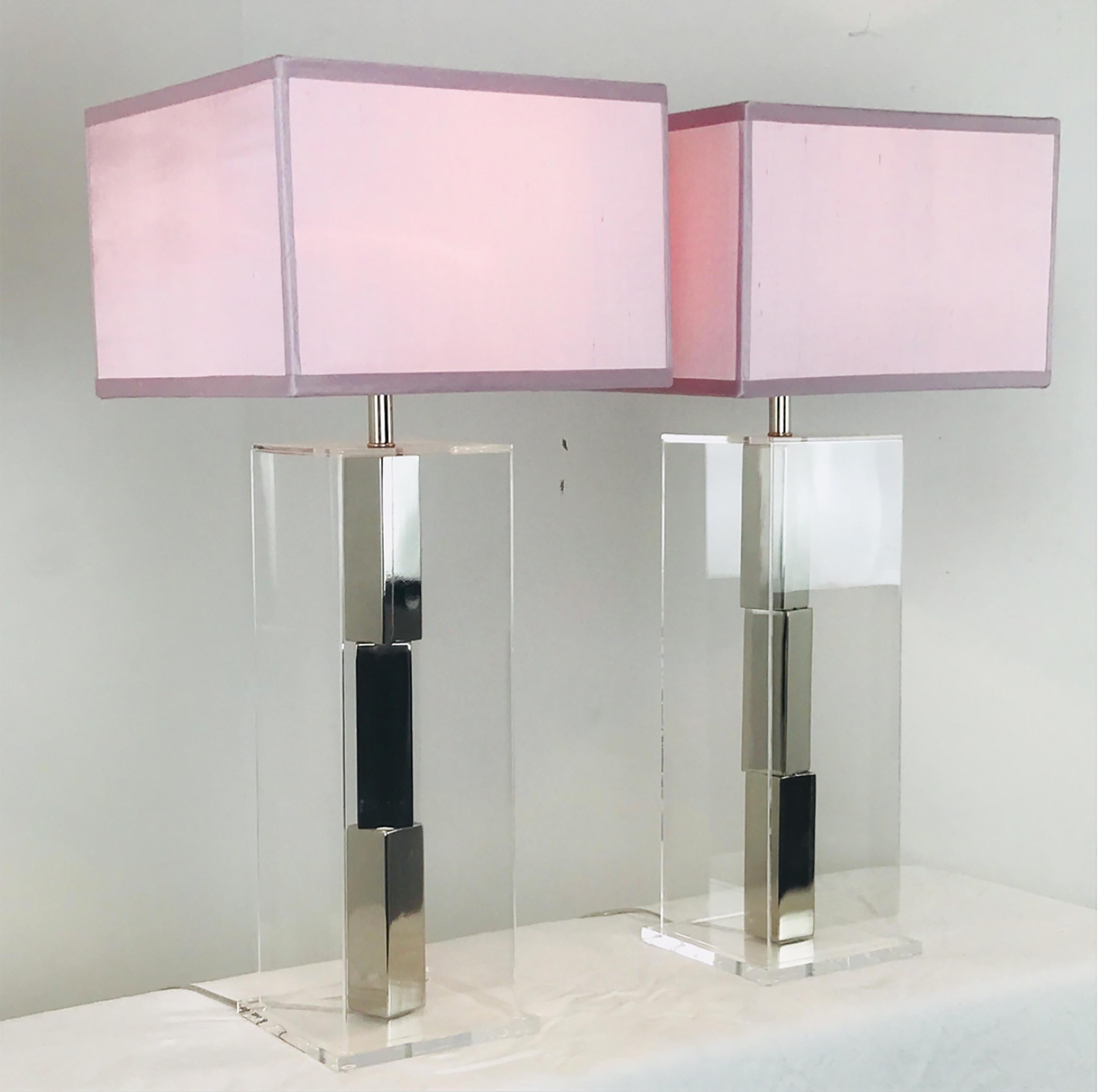 Pair of Lucite and chrome table lamps by Laurel. Chrome bars stacked in the center of a Lucite box. 
New Pink Silk shades are included.

Dimensions: 7