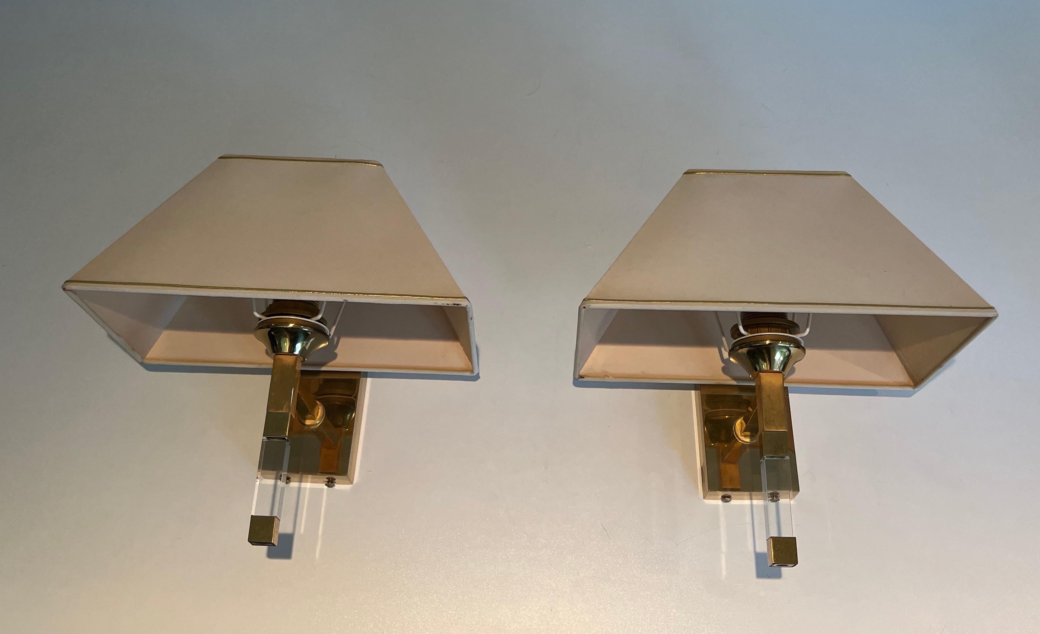 This pair of design wall sconces are made of lucite and gilt metal. This is a work in the style of famous French designer Maison Jansen, circa 1970.