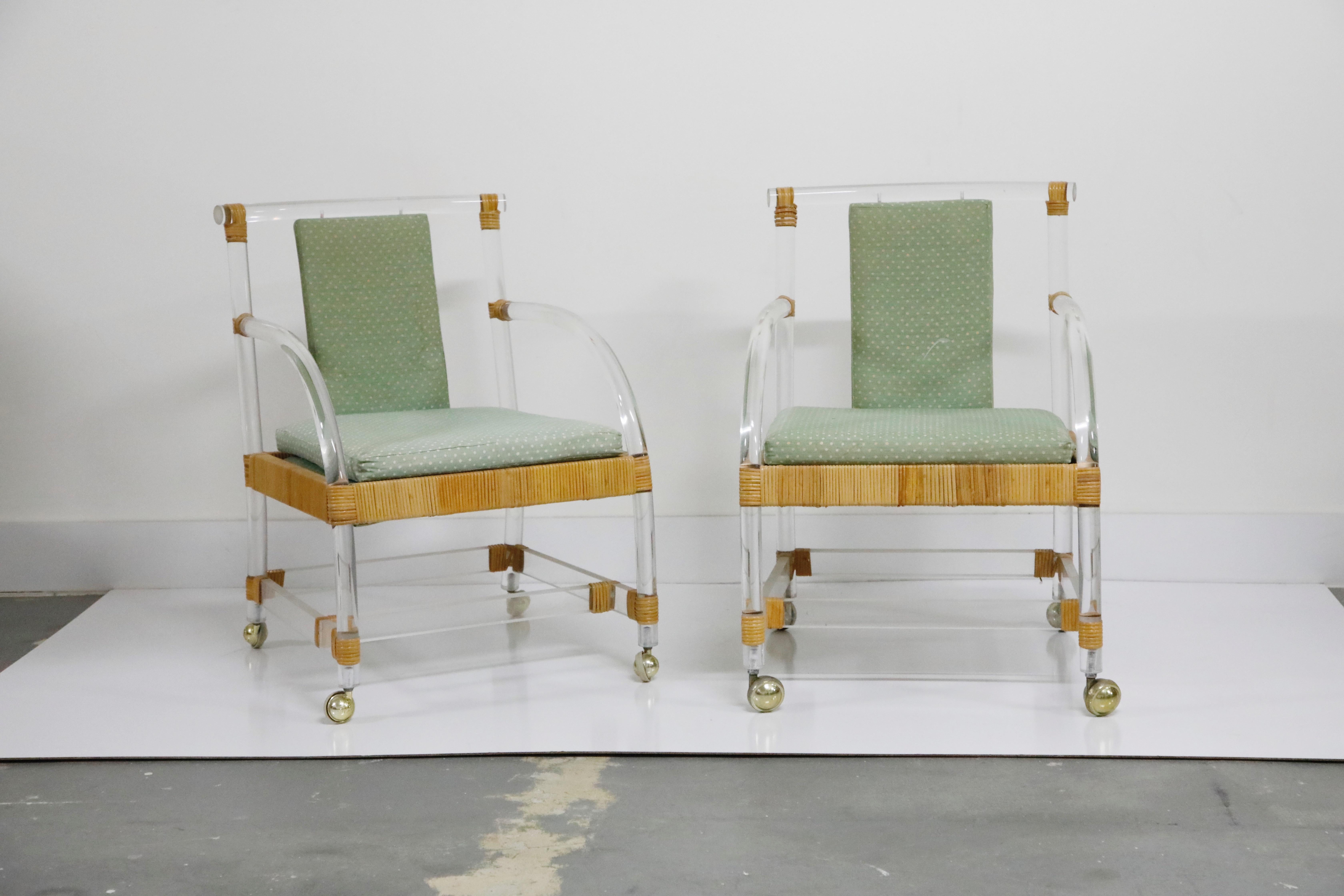 An extremely stylish and on-trend pair of lounge armchairs constructed from Lucite and rattan on top of casters by Ficks Reed, circa 1970s. This pair of laid-back armchairs would work excellent with an interior designer who is looking to combine the