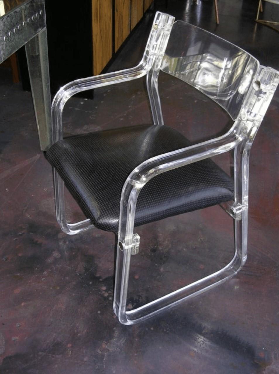 A functional pair of lucite armchairs. Seats are upholstered in embossed black leather. They are quite comfortable and would also make great desk chairs.