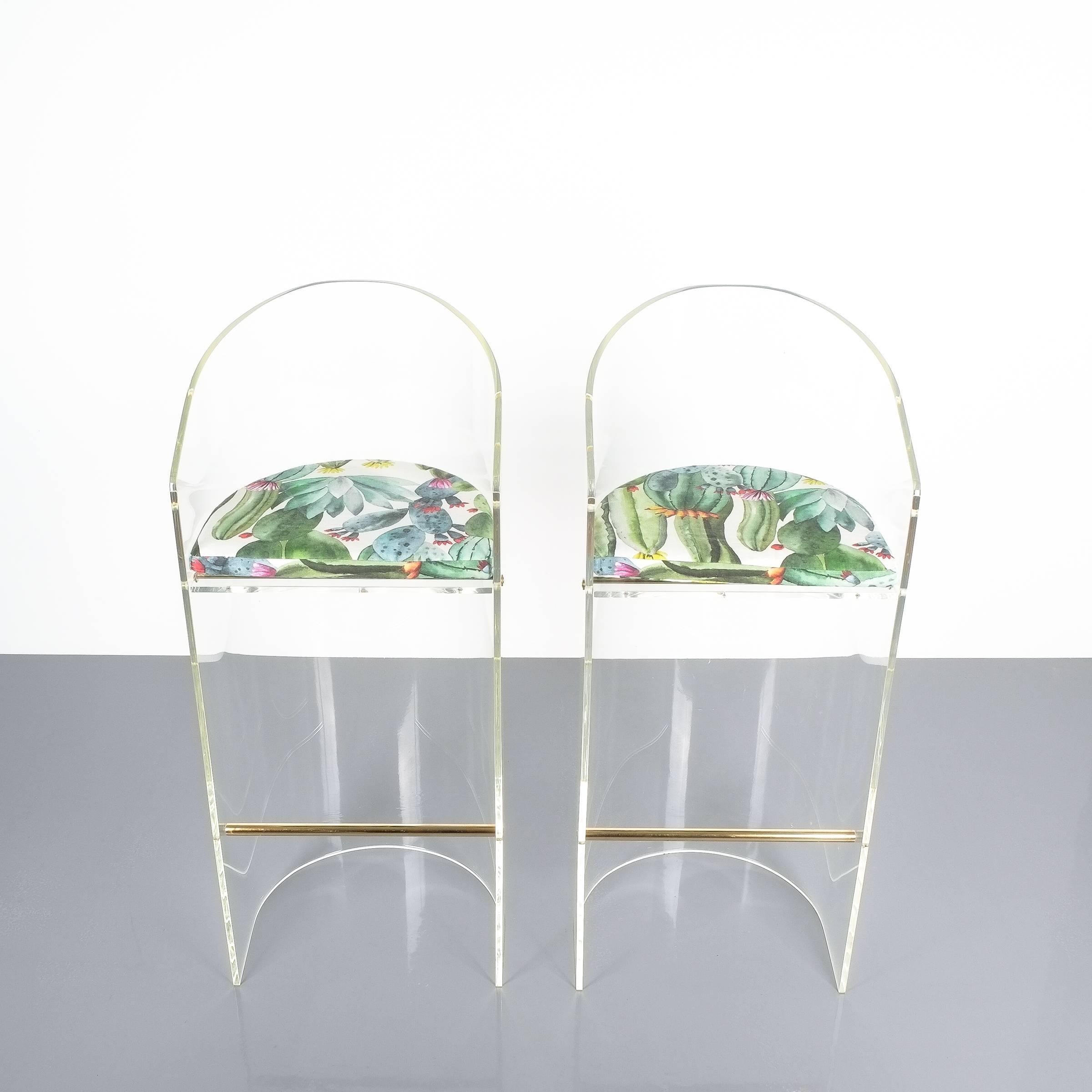 Pair of Lucite brass bar stools Style Charles Hollis Jones, 1960. Beautiful stools made from a single bend slab of perspex and brass details. Perfect for a kitchen. Both have been newly polished (brass and Lucite) and newly upholstered with