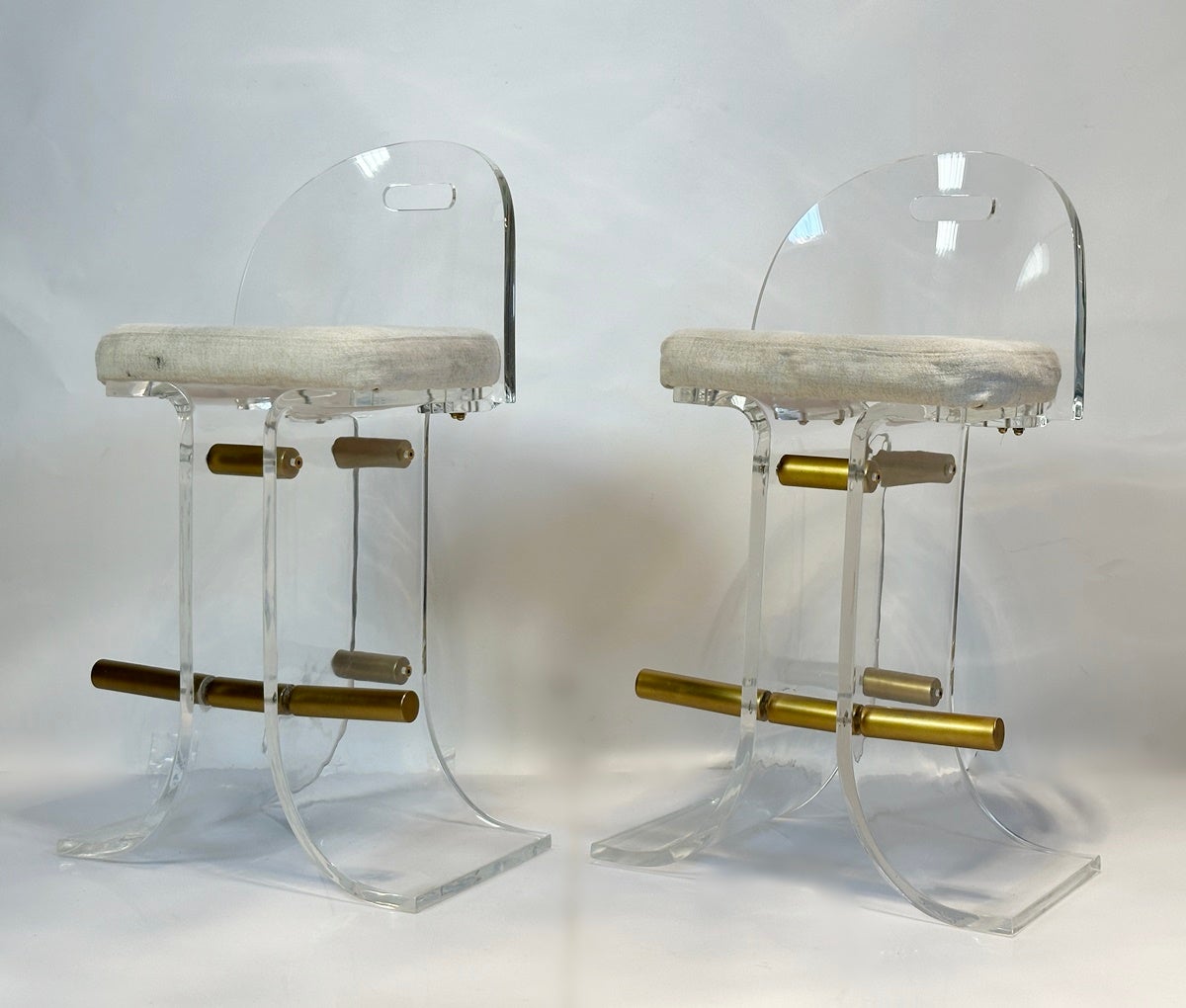 Introducing our exquisite Pair of Lucite & Brass Counter Stools by Hill Manufacturing, crafted in the USA during the stylish 1970s. These stunning stools effortlessly combine the elegance of Lucite and the opulence of brass, creating a truly