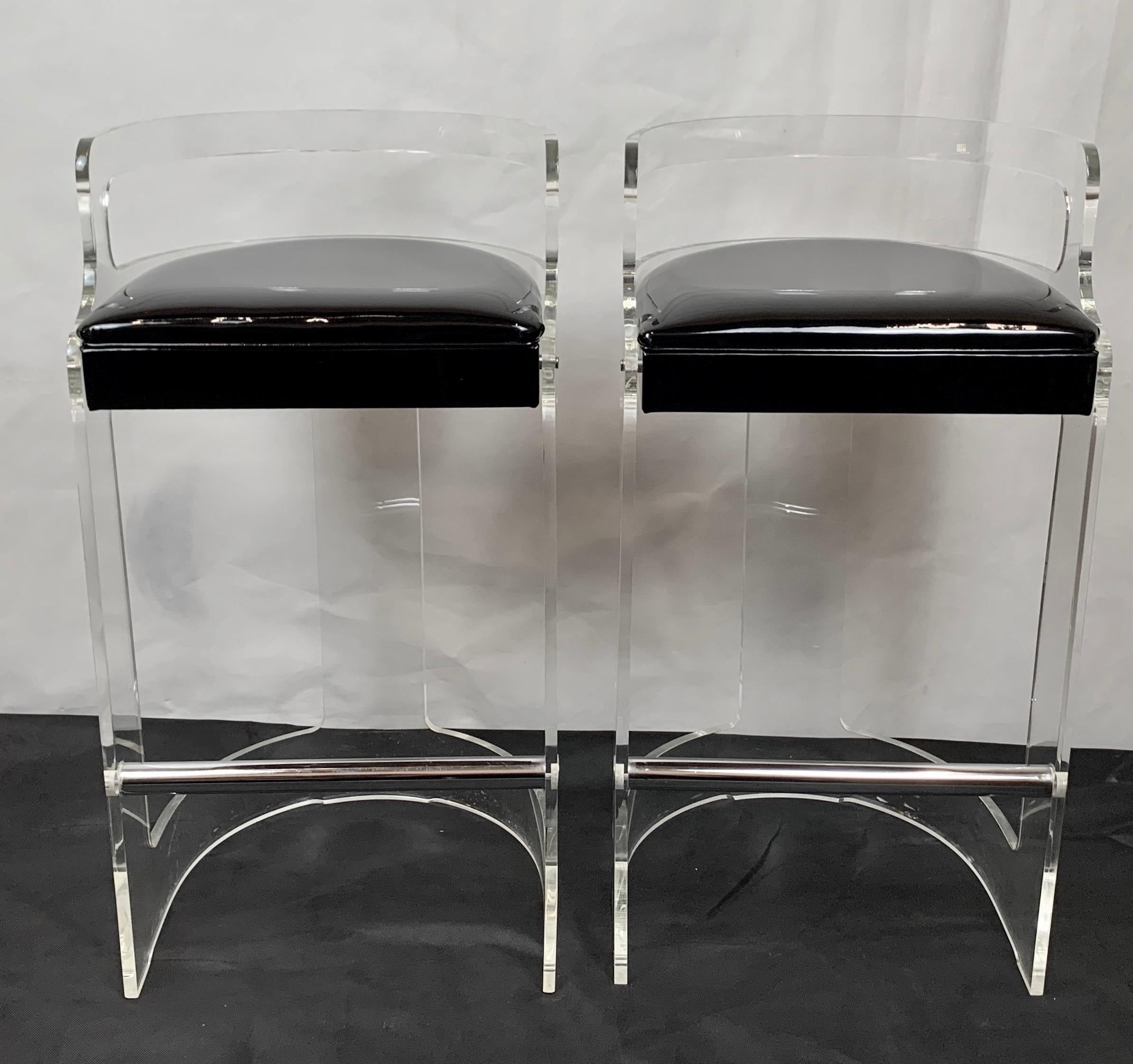 Pair of Lucite and chrome barstools designed by Charles Hollis Jones in the 1970s and produced by Hill Manufacturing. The barstools have the original black patent seat upholstery. The footrest is chrome, as well as, the chrome studs that hold the