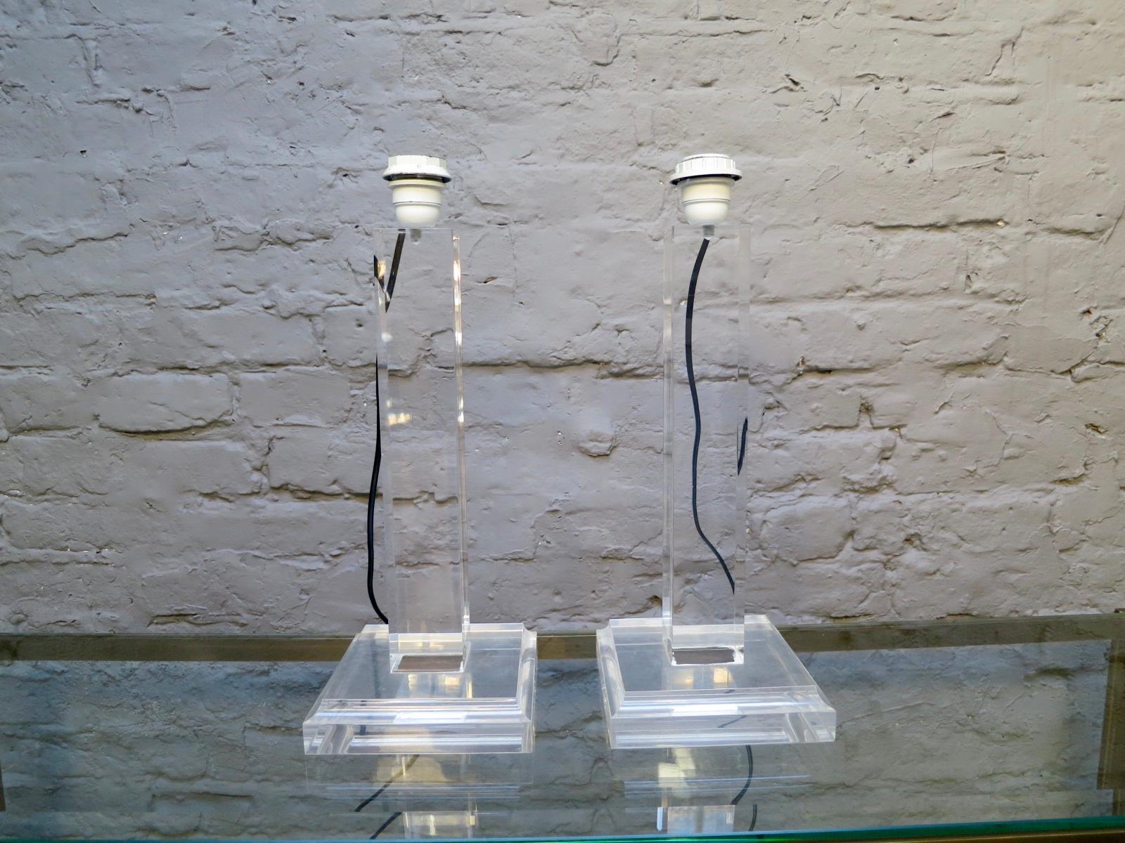 A pair of simply designed French Lucite table lamps, with columned uprights and square stepped bases. The color of the cable can be changed if desired.