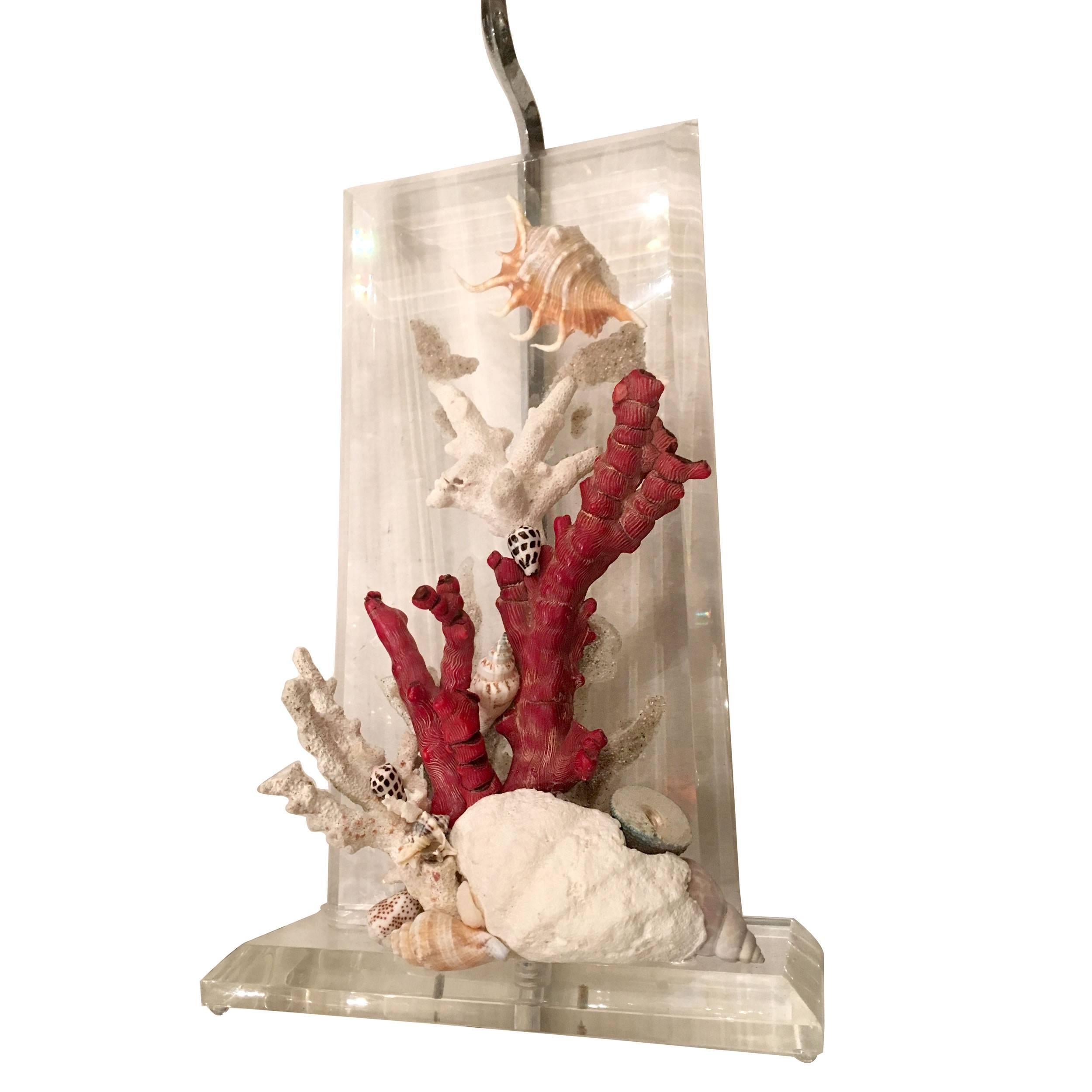 A pair of circa 1950s Lucite table lamps with natural coral and seashells on body.
Measures: 16