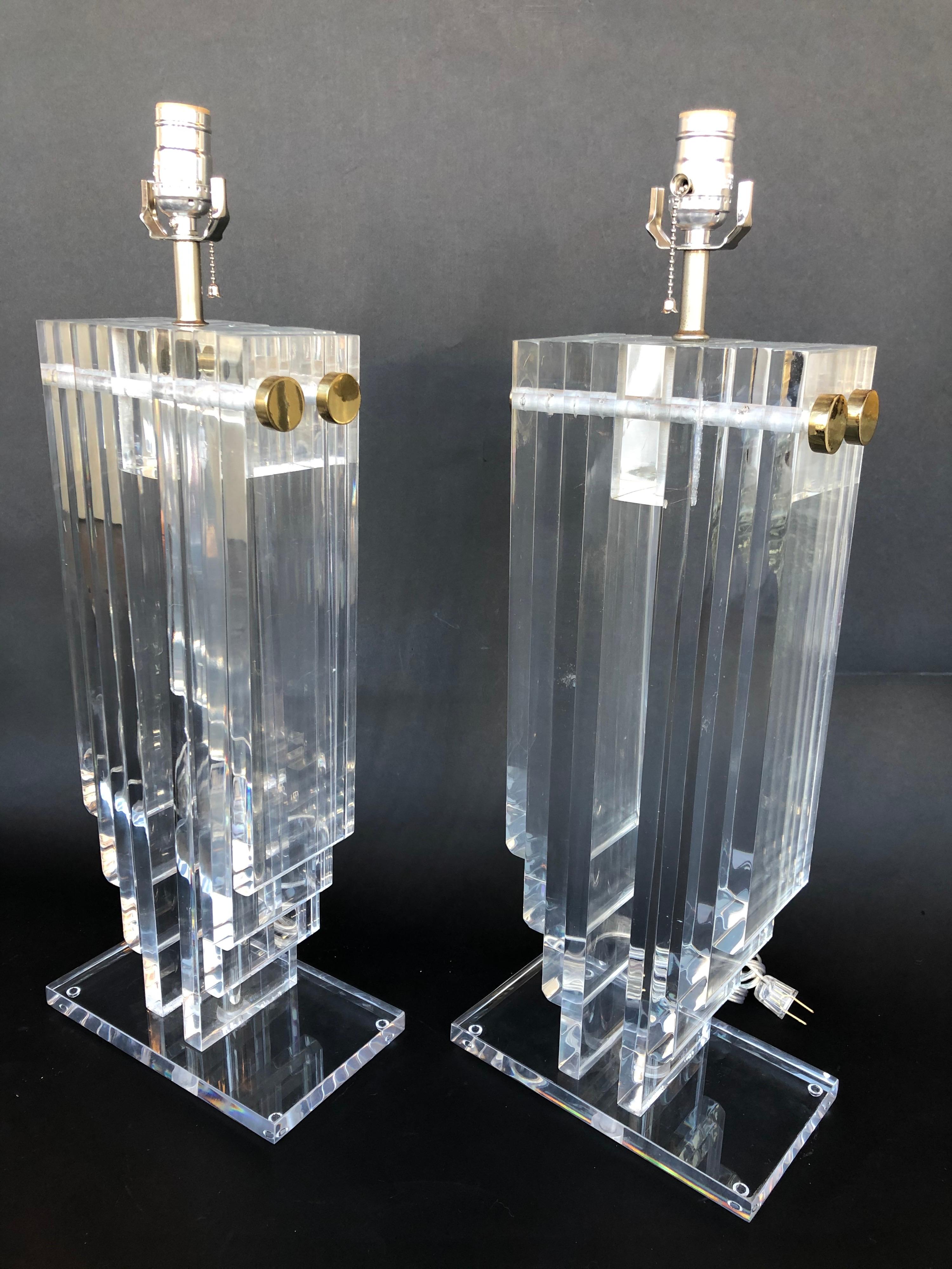 Pair of stacked Lucite table lamps with brass hardware.