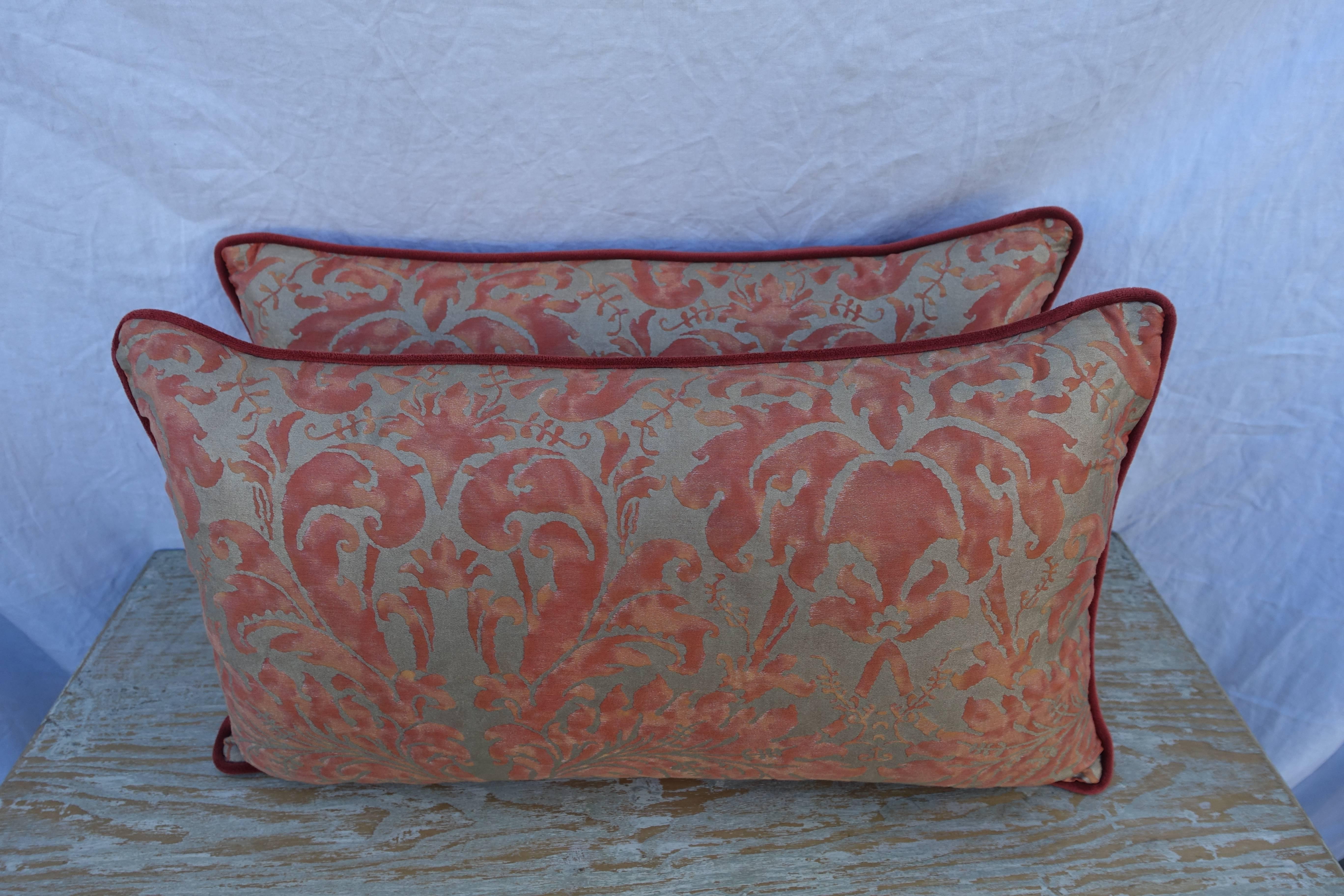 Pair of Lucrezia patterned Fortuny pillows in Bittersweet and silvery gold with coral backs and self cord detail. Down inserts, sewn closed.