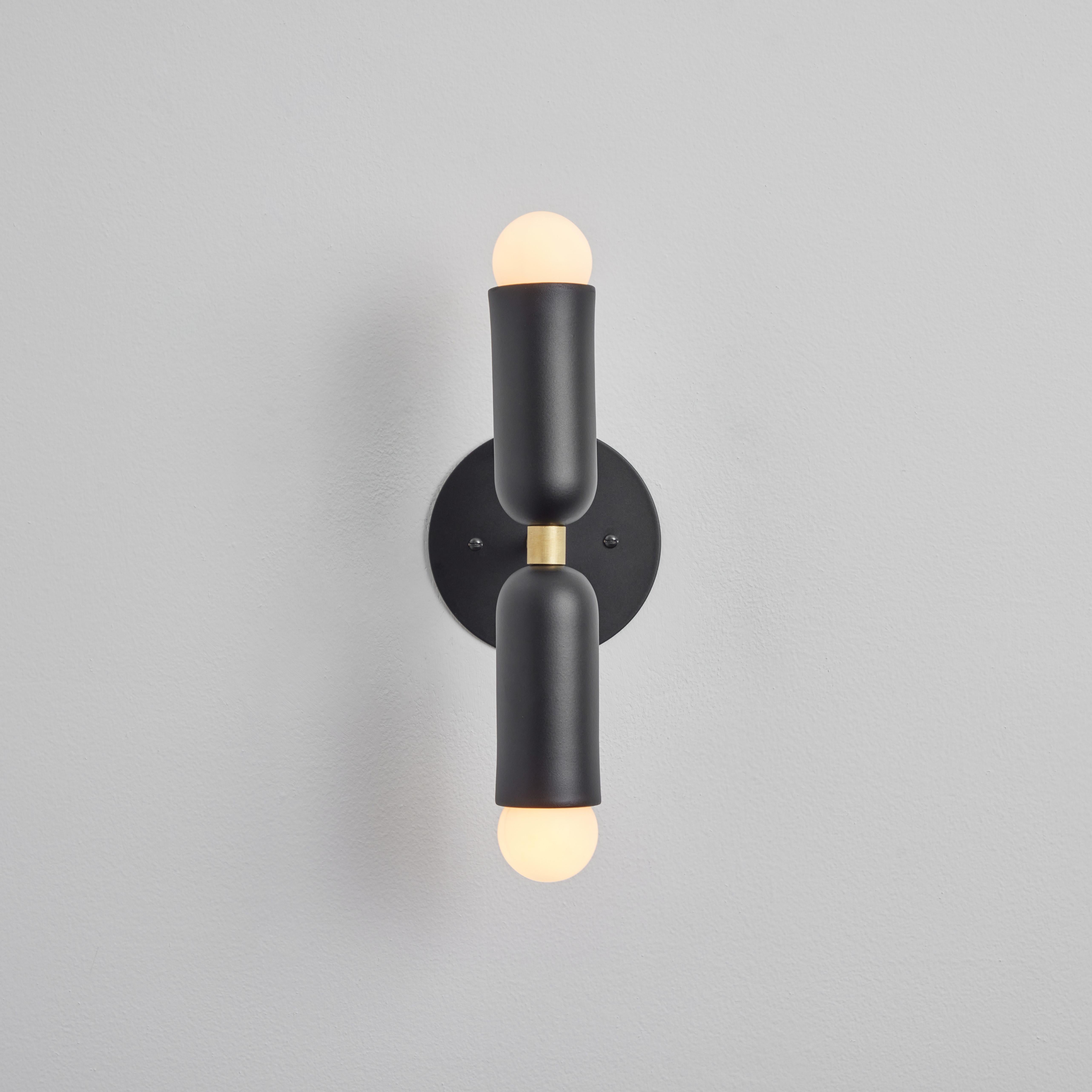 Pair of 'Lulu' sconces in black and brass. 

Hand-fabricated by Los Angeles based designer and lighting professional Alvaro Benitez, these highly refined sconces are reminiscent of the iconic midcentury Italian designs of Arteluce and Stilnovo.