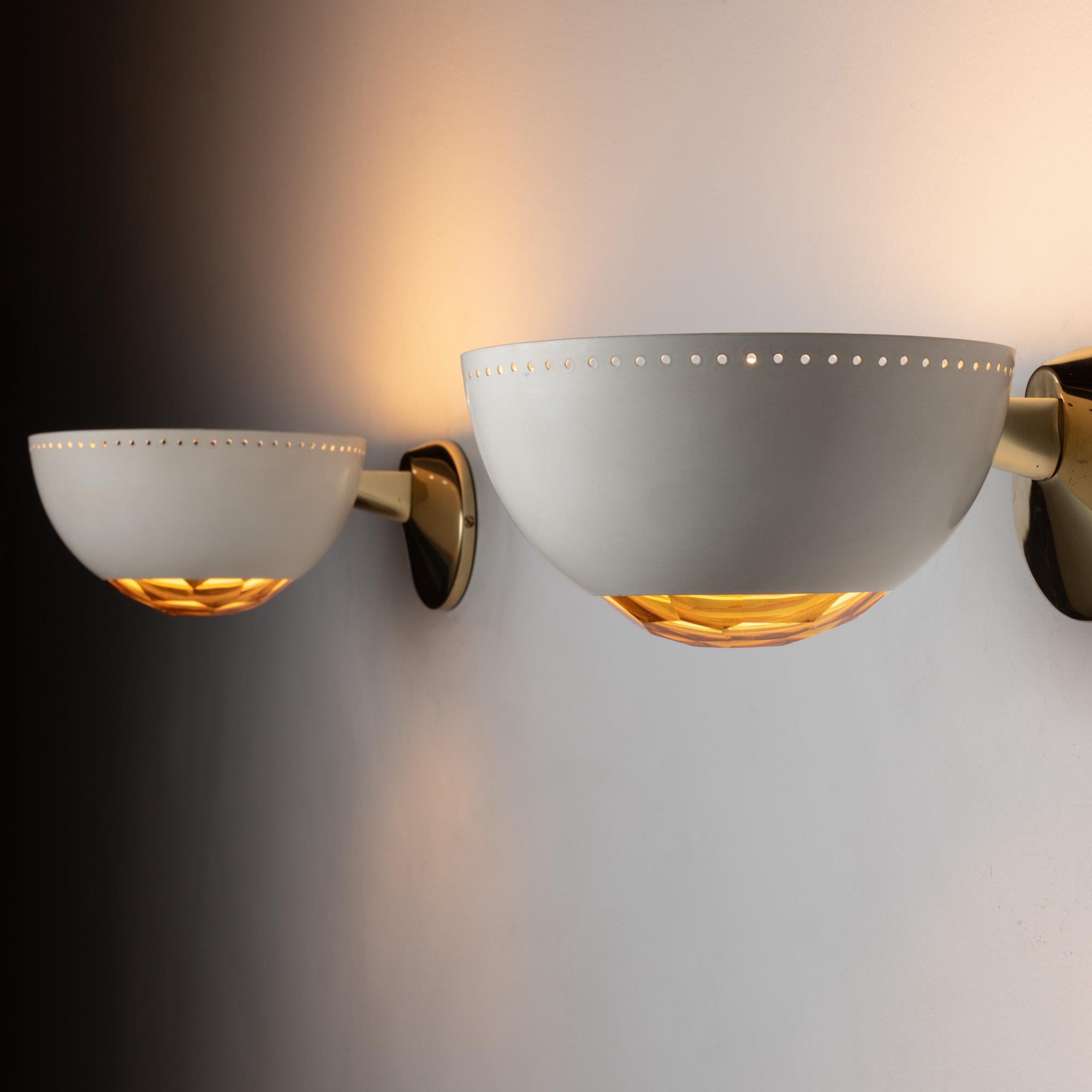 Pair of Lumi sconces. Designed and manufactured in Milan, Italy circa 1950's. Enameled, glass, metal, brass. Rewired for U.S. standards. We recommend one E26 60w maximum bulb per fixture. Bulbs not included.