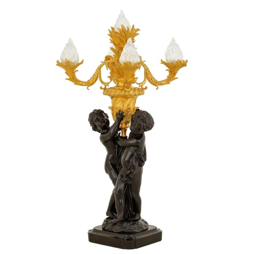 Ces exceptionnels candélabres torchères de style Louis XVI témoignent de l'attrait durable du design néoclassique. La juxtaposition des chérubins en bronze patiné, plus sombres, et des surfaces plaquées or 24 carats, plus brillantes, crée un jeu