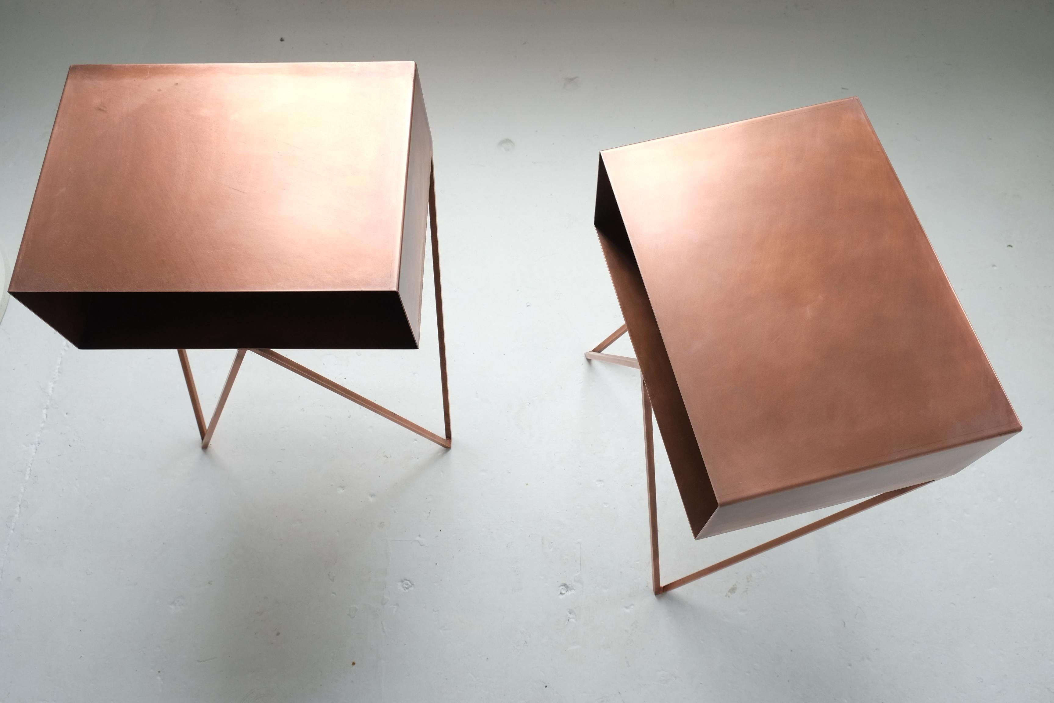 A pair of Robot side tables in oxidized copper. Each Robot table is individually coated in copper so they all have an absolutely unique finish. The tables are then hand-finished with beeswax for protection. The look of the side tables changes over