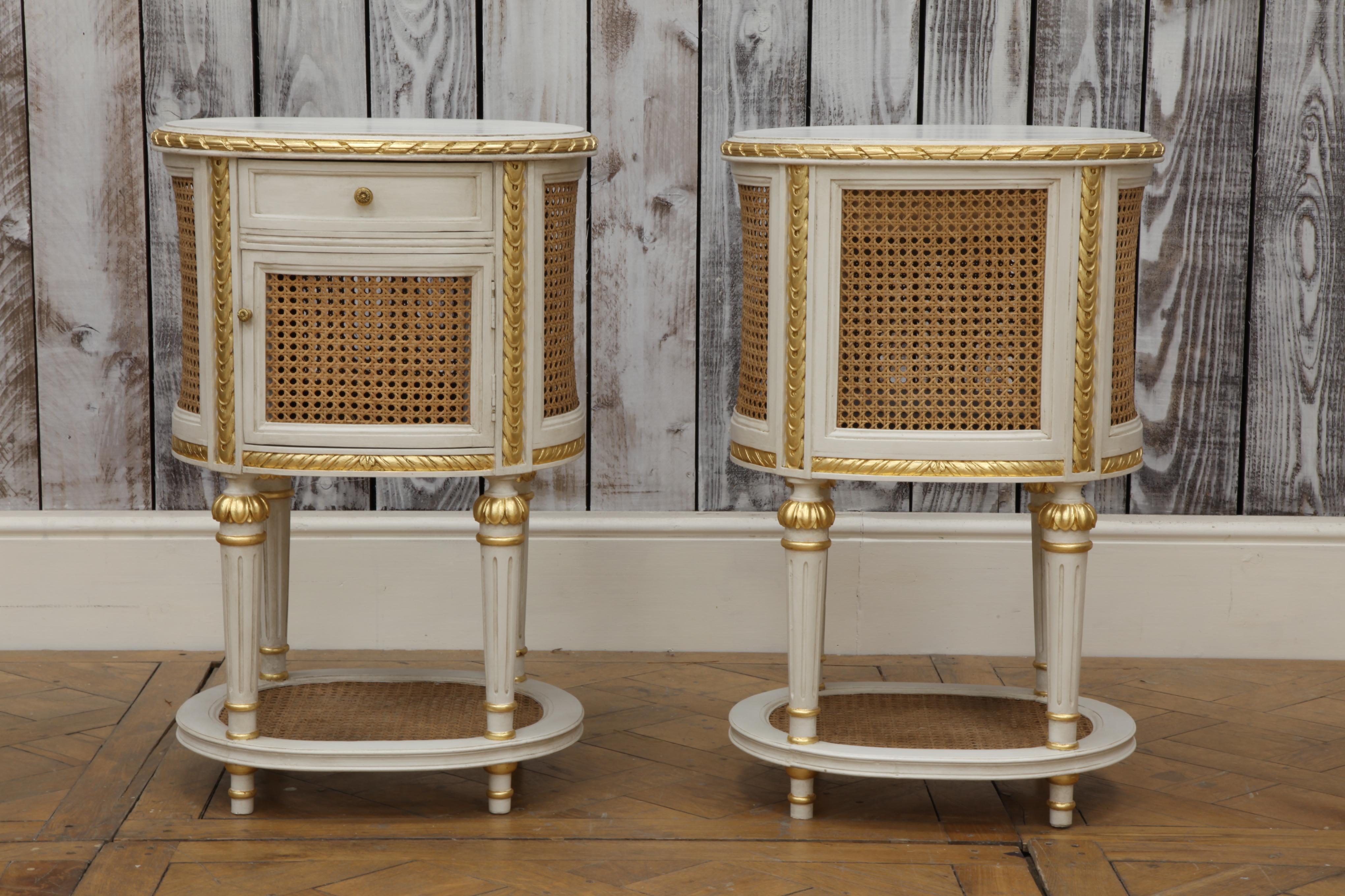 A pair of bedside tables in the LXVI style made by the master craftsmen of La Maison London, finished, in house, in an old white patina highlighted with hand applied, antique gold highlights to accentuate the carved details of the period's styling.