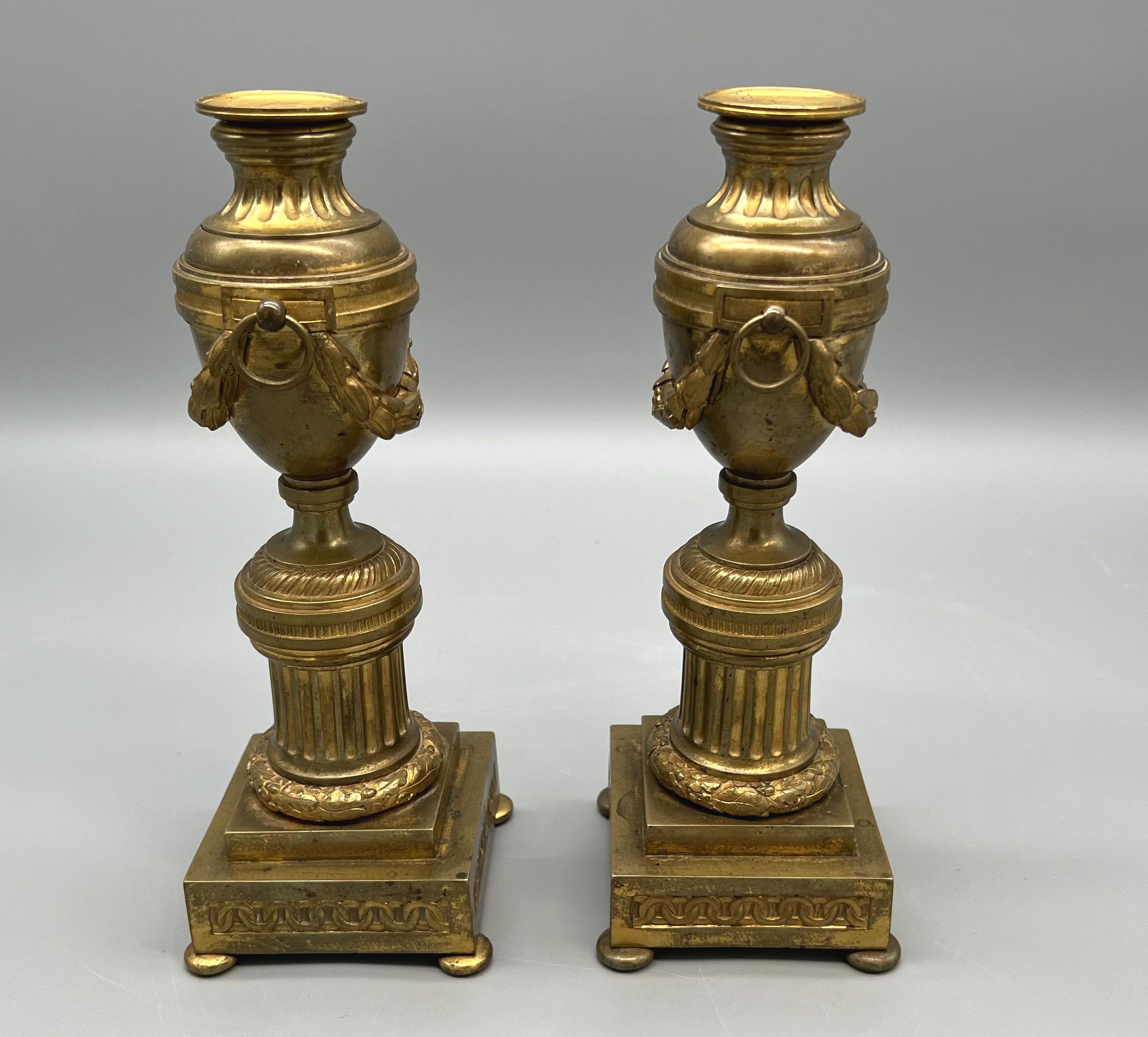 Coppia di cassette portacandele in ormù a forma di piedistallo coperto con decorazione neoclassica a ghirlanda d'alloro, su fusti a forma di sezioni di colonne antiche su una base quadrangolare decorata con un fregio di ovali. Fine del XVIII