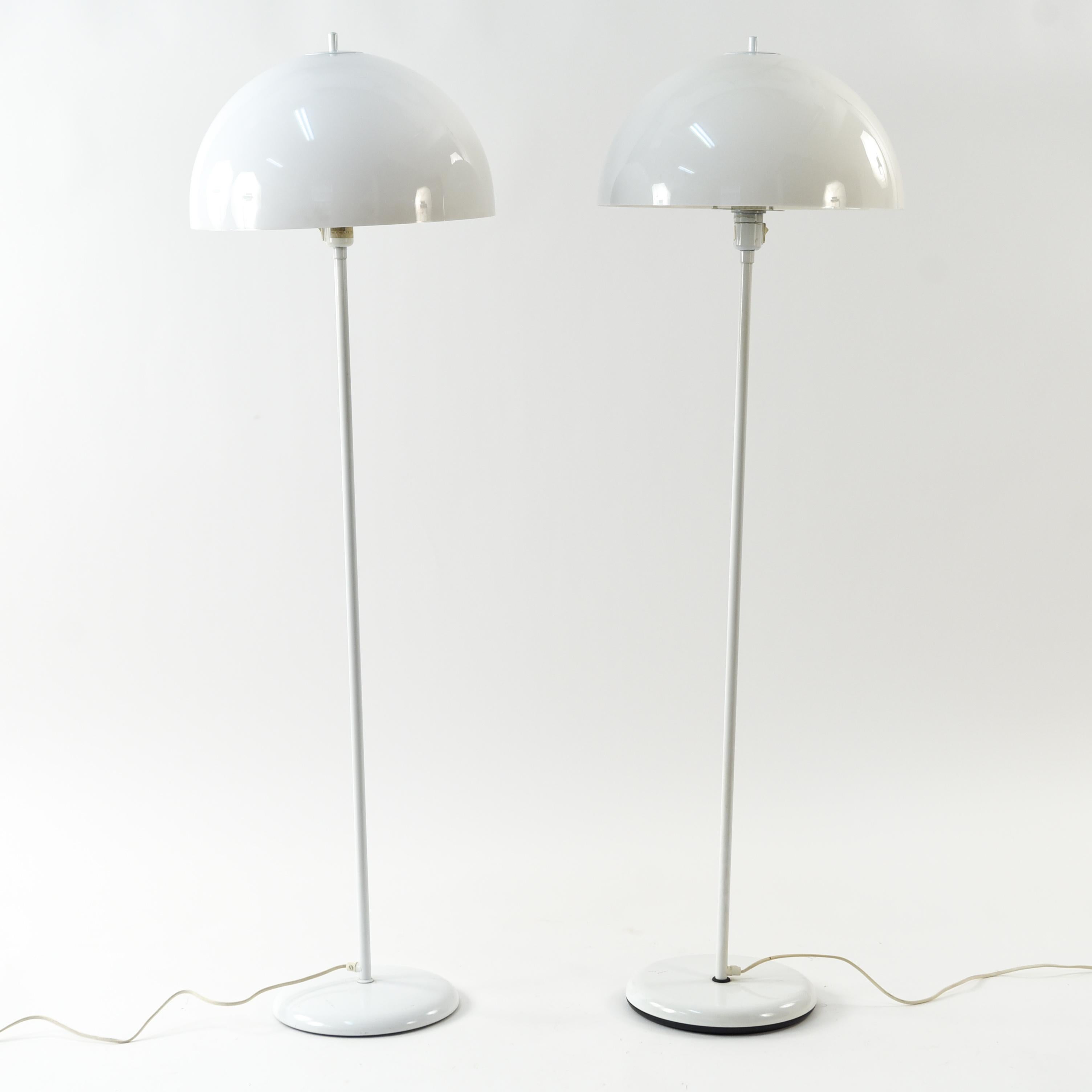 This pair of floor lamps are by Lyfa and feature white acrylic shades. The hemisphere shade is characteristic of many Danish midcentury designs and gives these lamps a Classic appearance. The white color allows the lamps to retain their clean,