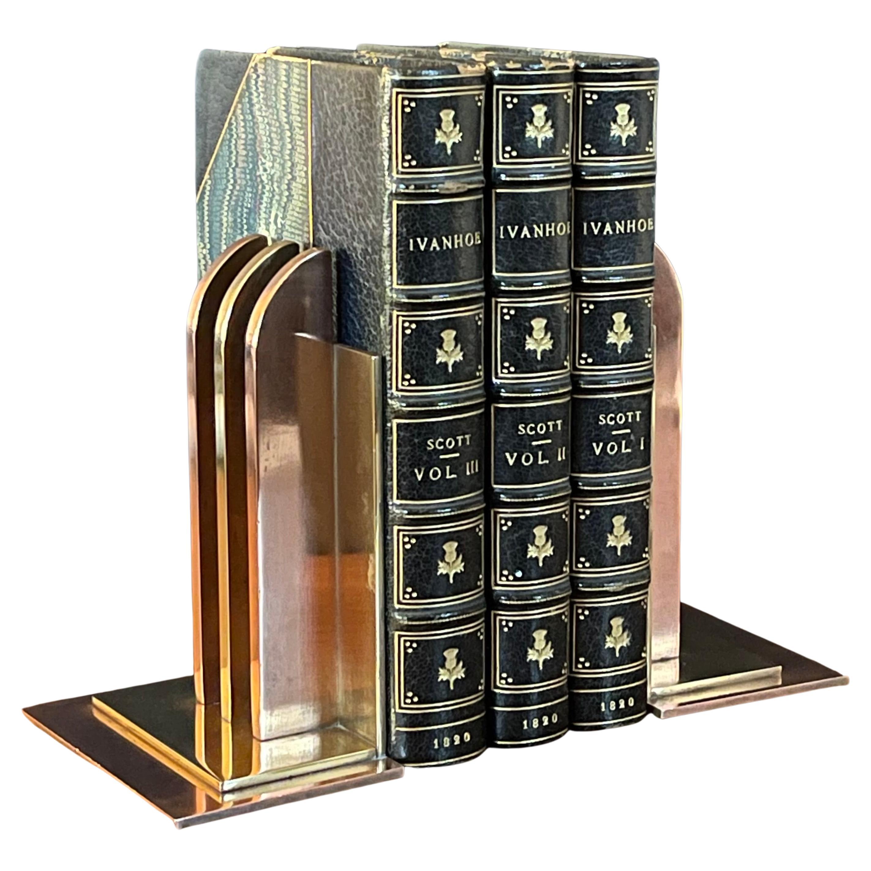 Gorgeous pair of machine age art deco bookends by Walter Von Nessen for Chase & Co., circa 1930s. These are solid brass and copper bookends with three perpendicular rounded beams along a square back. The bookends are in very good vintage condition