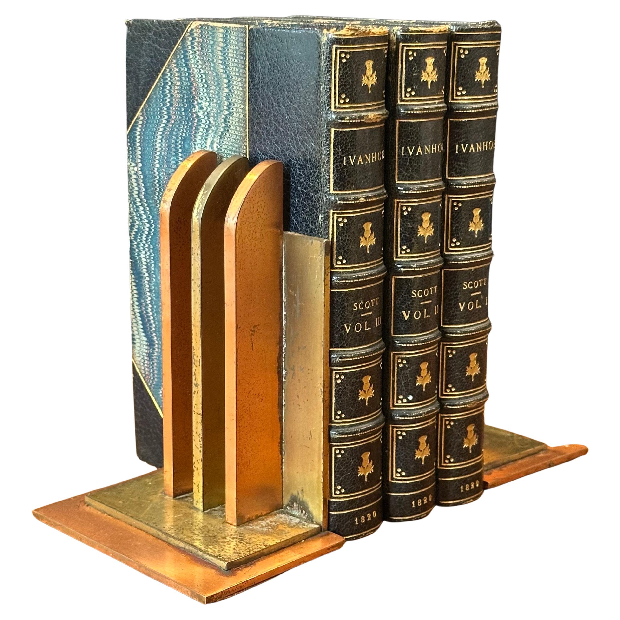 Magnifique paire de serre-livres art déco de l'âge de la machine par Walter Von Nessen pour Chase & Co, vers les années 1930. Ces serre-livres en cuivre et laiton massif présentent trois poutres arrondies perpendiculaires le long d'un dos carré. Les