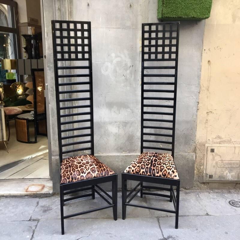 Pair of high back chairs in black lacquered wood by Mackintosh, seat with printed fur. They are solid and their unusual height it's really impressive.
 