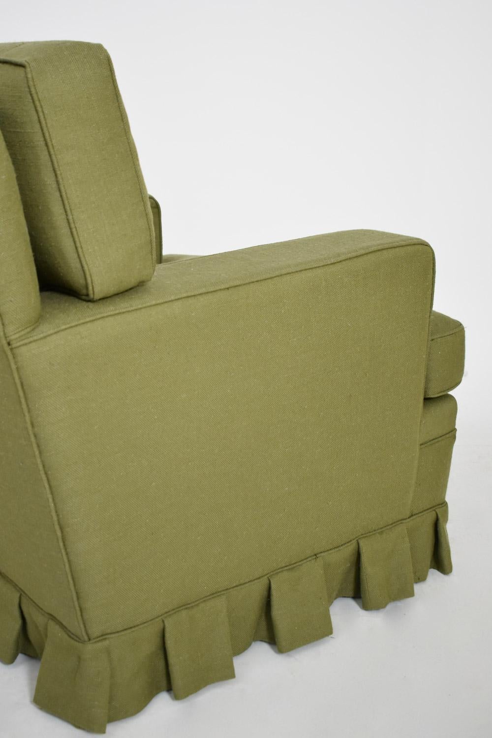 Pair of Madeleine Castaing style green fabric armchairs, with a notched fringe in the down part. France, 1960s.