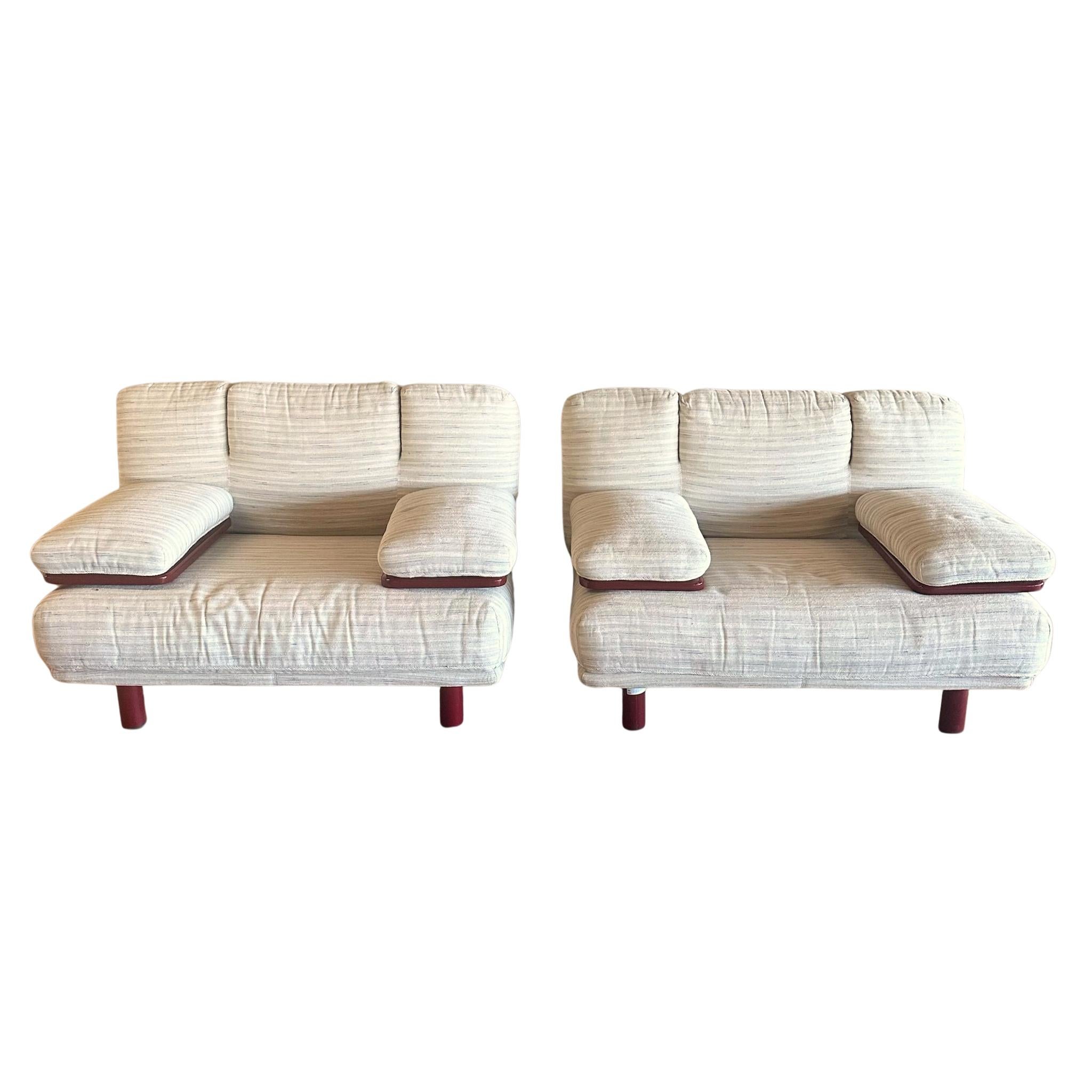 Designed by Bacci and Mazzoni for Giovannetti in the 1980s, this pair of Magia lounge chairs captures the playful geometry of Italian postmodernism. The tubular forms are upholstered in original cream striped fabric and feature rounded cushions set