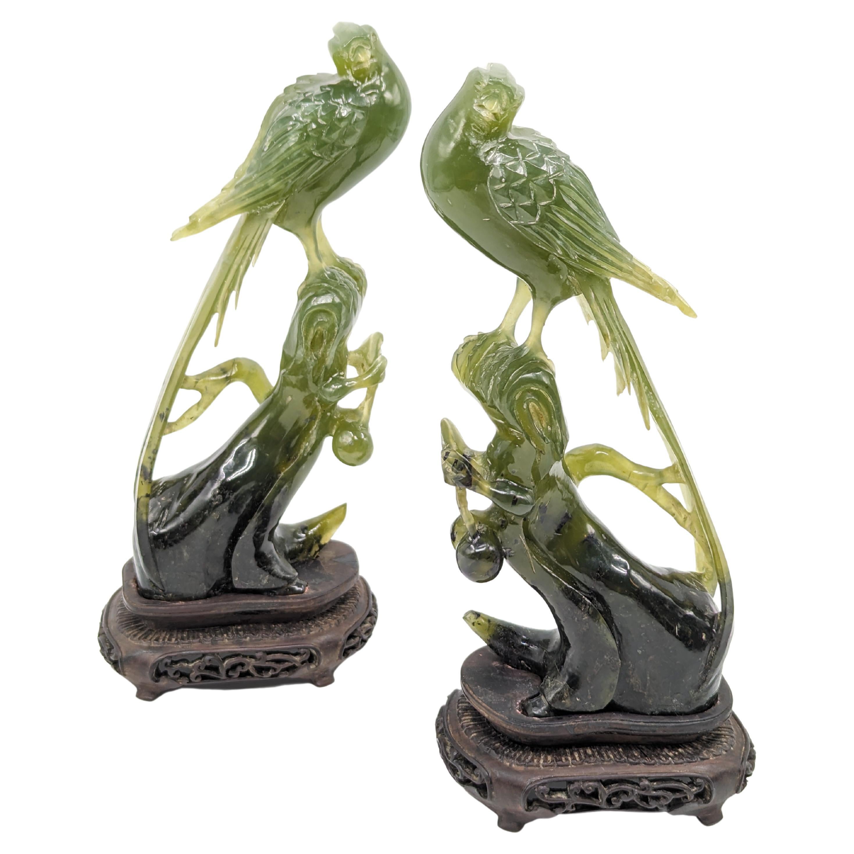 Presenting a magnificent pair of Chinese carved jade birds of prey, a true testament to the intricate artistry and craftsmanship synonymous with Chinese jade sculpting. These exquisite figures stand majestically on intricately carved fruit tree