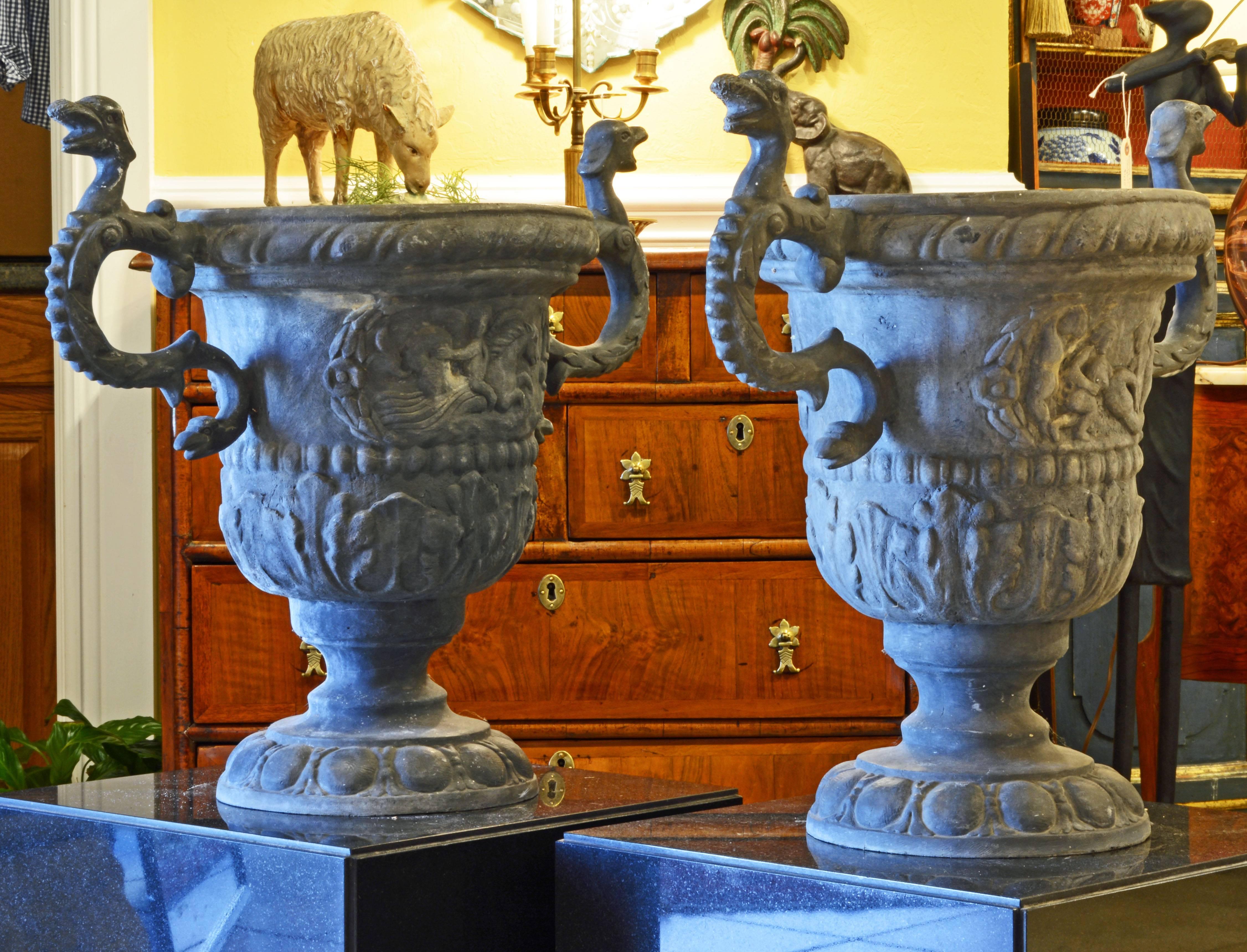 Standing 22 inches tall this pair of lead urns will be impressive both outdoors and indoors. The handles are fashioned as double headed serpents and the main body features classical mythological reliefs above archantus borders.