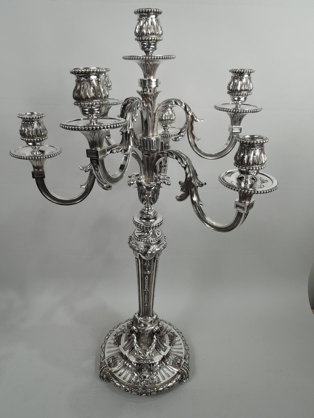 Pair of magnificent French neoclassical 950 silver 7-light candelabra, ca 1880. Each: Six leaf-wrapped s-scroll arms each terminating in single leaf-and-dart socket, mounted to central socket on shaft set in petal mount on knopped and tapering