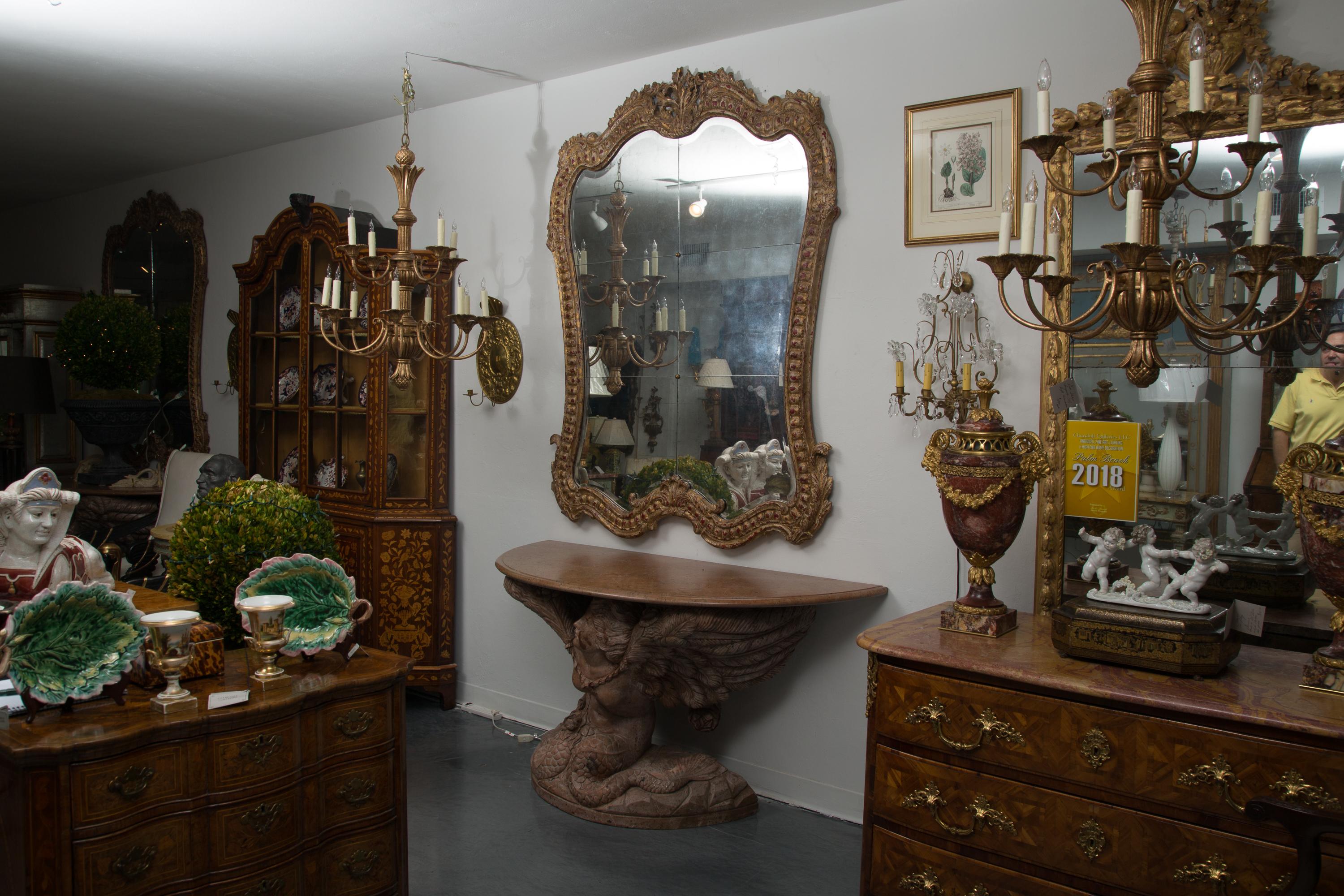 These stunning Italian mirrors make a dramatic statement with the distressed yet sophisticated gilt carved frame and rouge under coating. The interior section has been mirrored in rectangular panels separated with a decorative button enhancing the