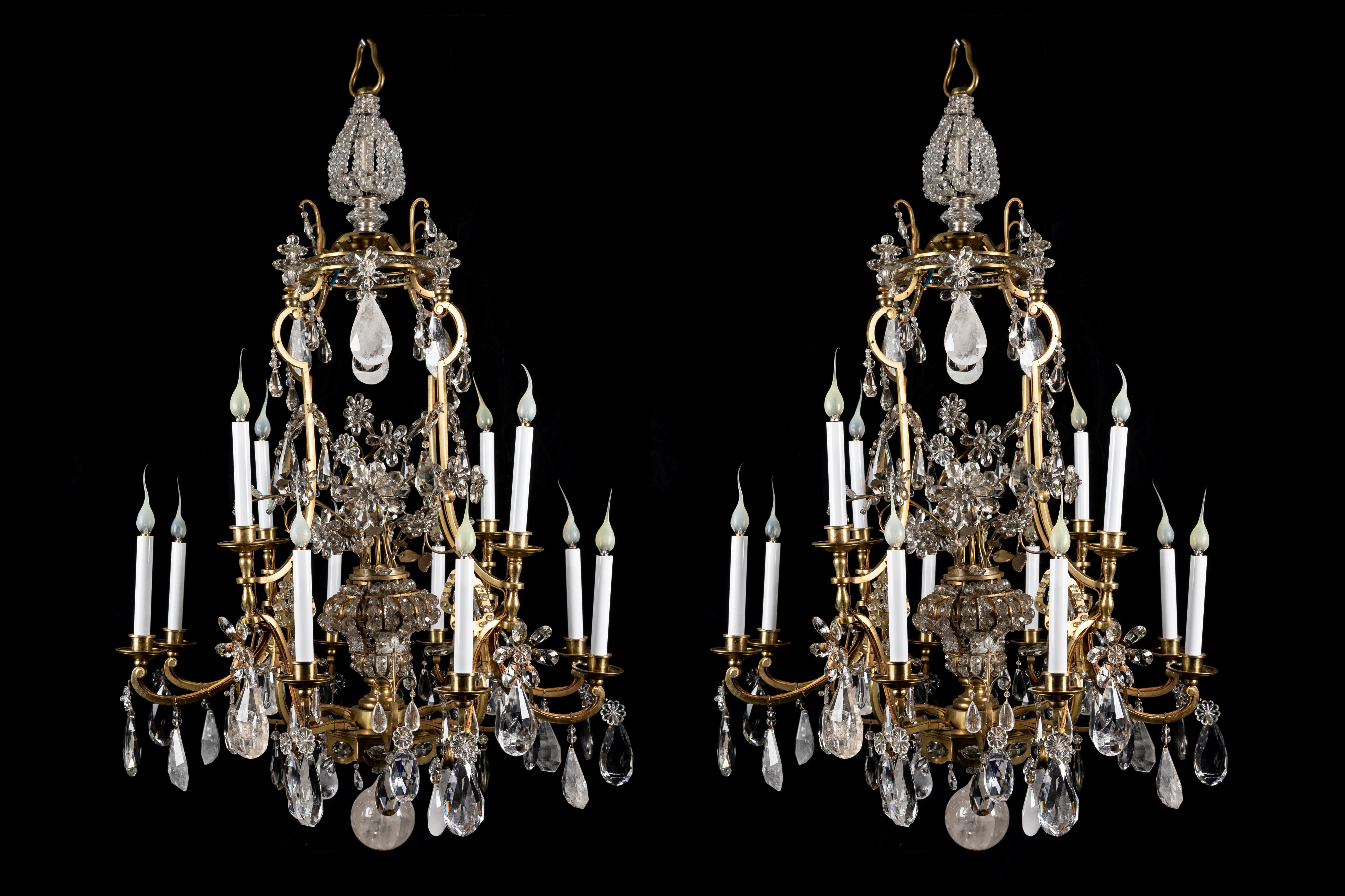 Questa grandiosa e luminosa coppia di lampadari a gabbia in cristallo di rocca e bronzo dorato in stile Luigi XVI della Maison Baguès è riccamente ornata da gocce sfaccettate e getti floreali in cristallo.
Ogni grande lampadario presenta 12 bracci