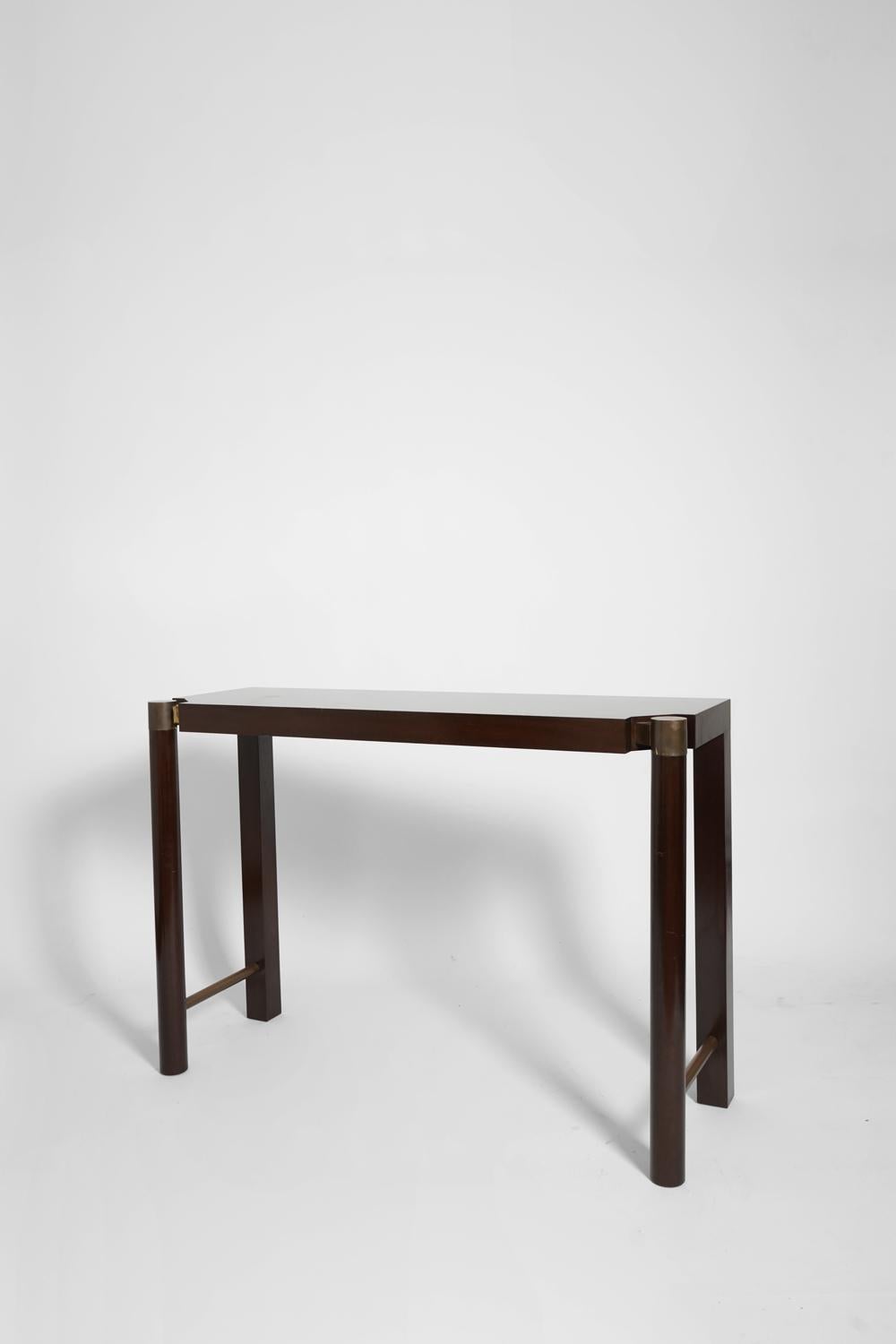 Pair of mahogany and mahogany veneer consoles rectangular shaped top, shaped and smooth front legs with golden metal applications and bracing. Portugal, 1970s.