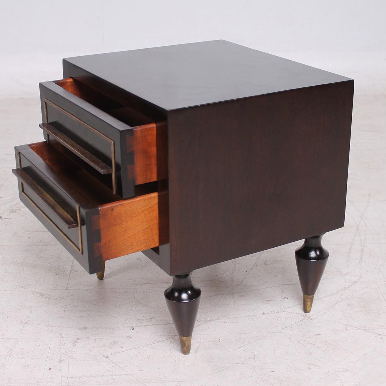 Wonderful display of Mexican Modernism with this pair of Mahogany & Brass Nightstands. Made in Mexico circa 1950s
Attributed to Eugenio Escudero. Unmarked no signature or label present from the maker. 
Nightstands supported by to die for sculptural