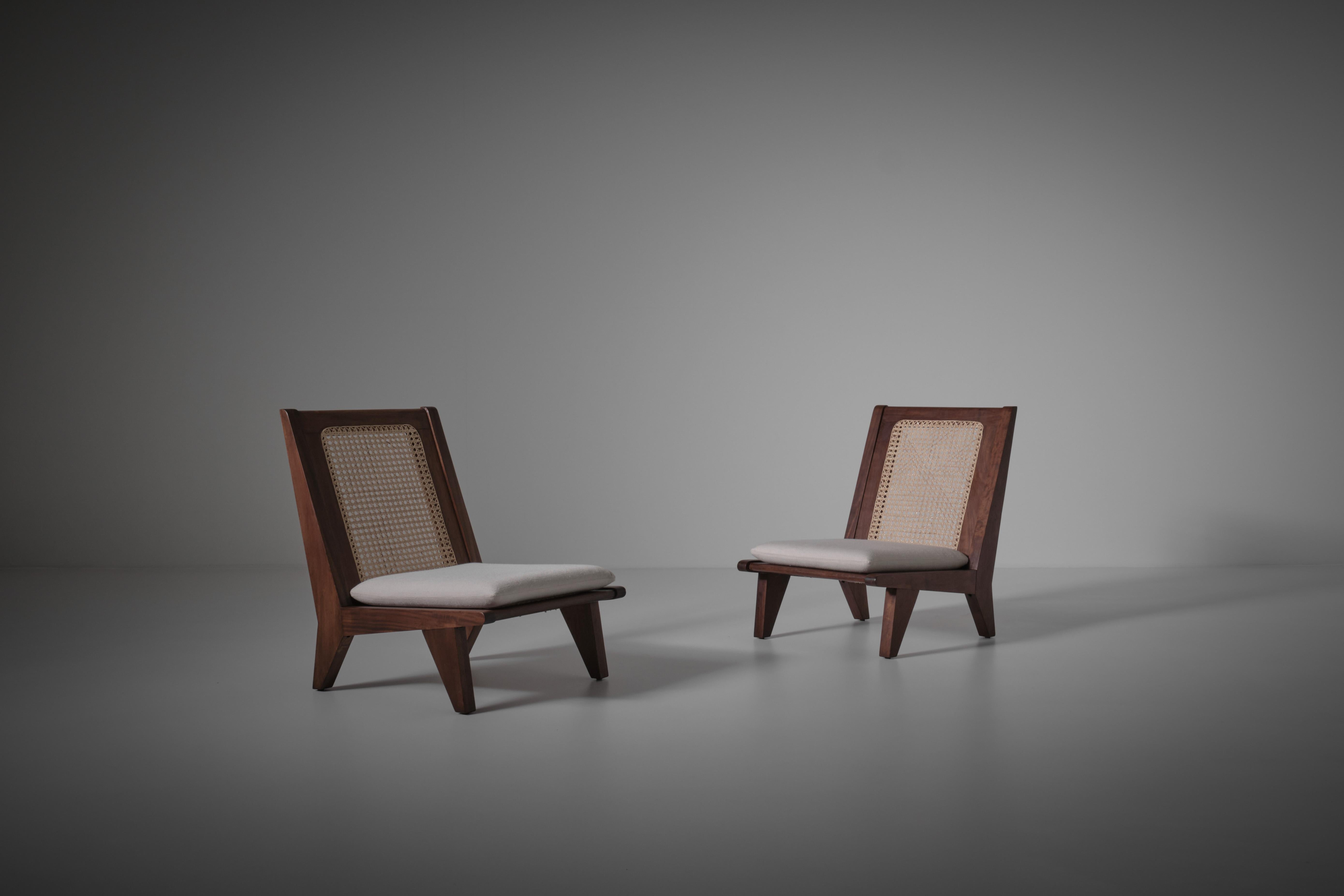Pair of French easy chairs, France 1950s. Elegant frame made of Mahogany and woven cane back and seat. Cushions are made of a high quality woven natural fabric composed of Viscose (Rayon) and silk from the collection of Dedar. In excellent condition.