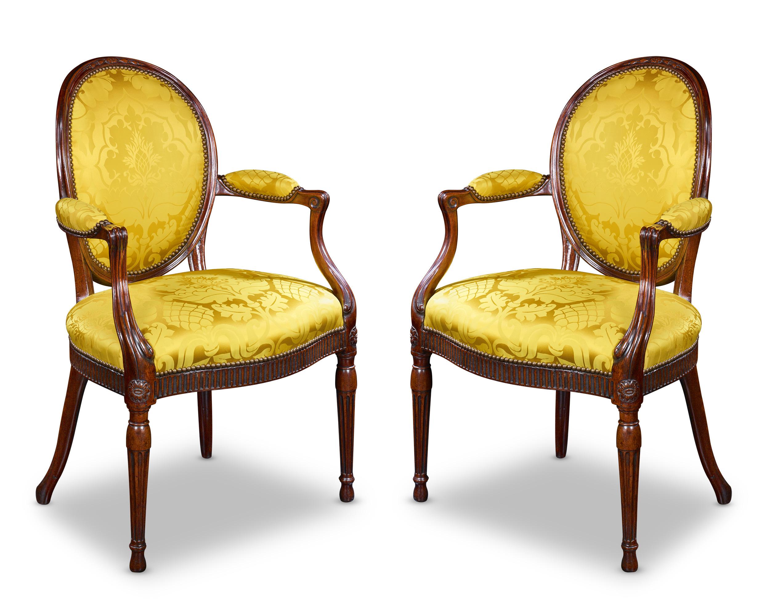Dieses Set aus zwei Mahagonistühlen wurde von dem unnachahmlichen und famosen Thomas Chippendale gefertigt. Die gelb gepolsterten Sitze ergänzen das tiefe Mahagoni wunderbar und schaffen ein elegantes Gleichgewicht. Das Talent und die Genialität der