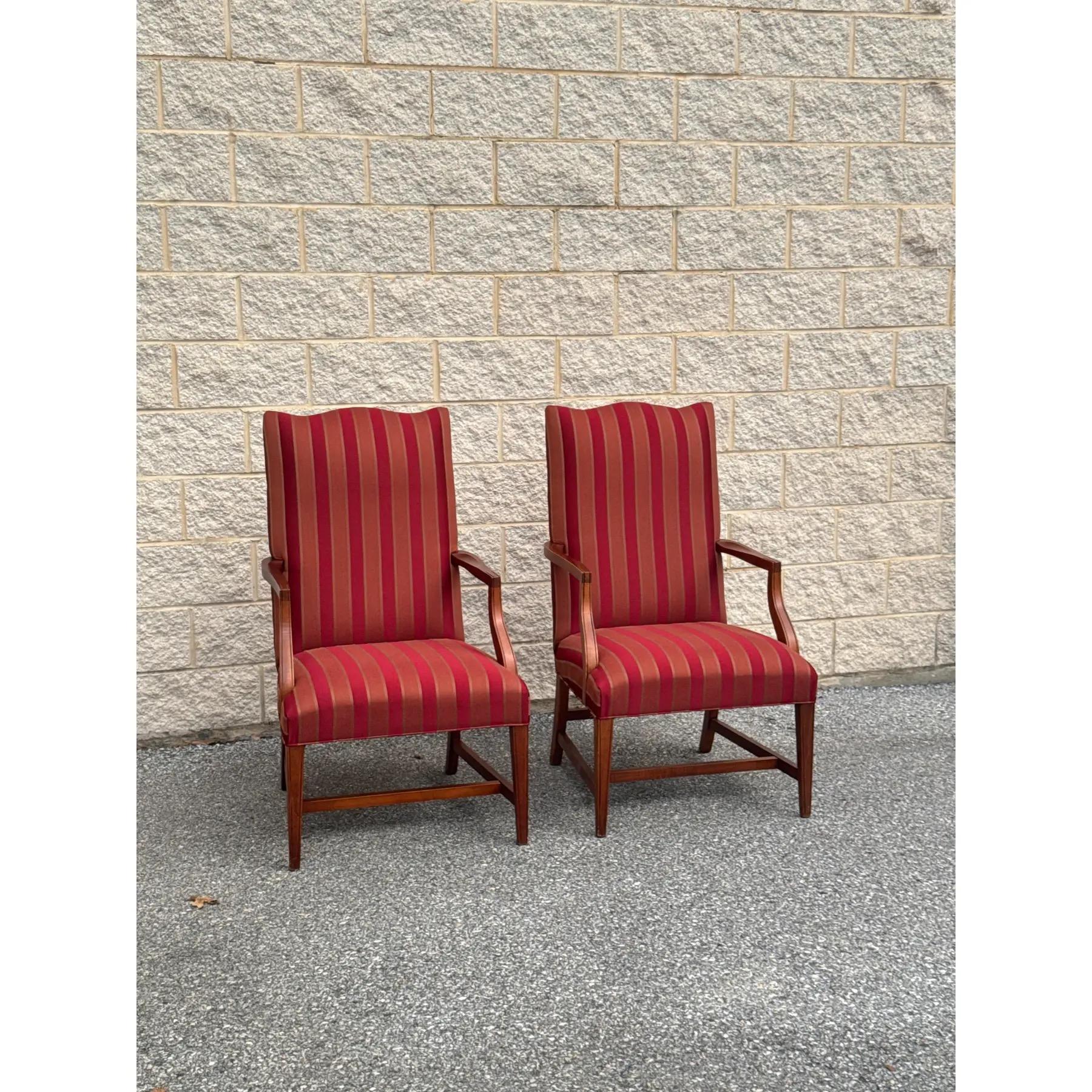 Un'elegante coppia di poltrone in mogano in condizioni immacolate, con una classica tappezzeria a righe rosse e oro.

