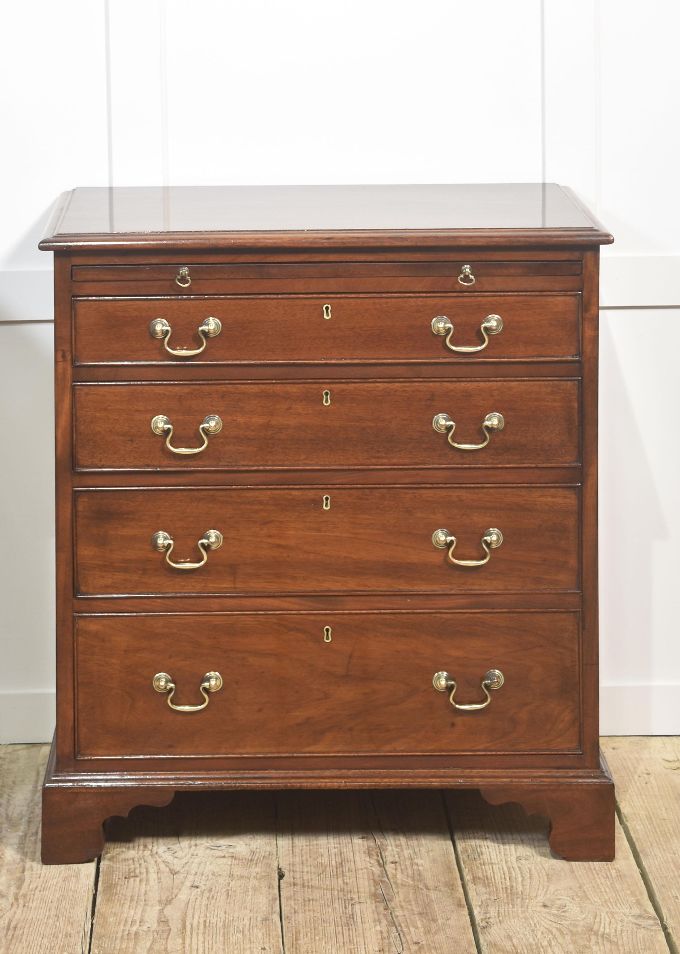A fine matching pair of mahogany bachelor’s chests, each with four graduated drawers and a pull-out brushing or writing slide above. Beautifully proportioned and crafted from richly figured mahogany, the chests display a warm, well-polished patina