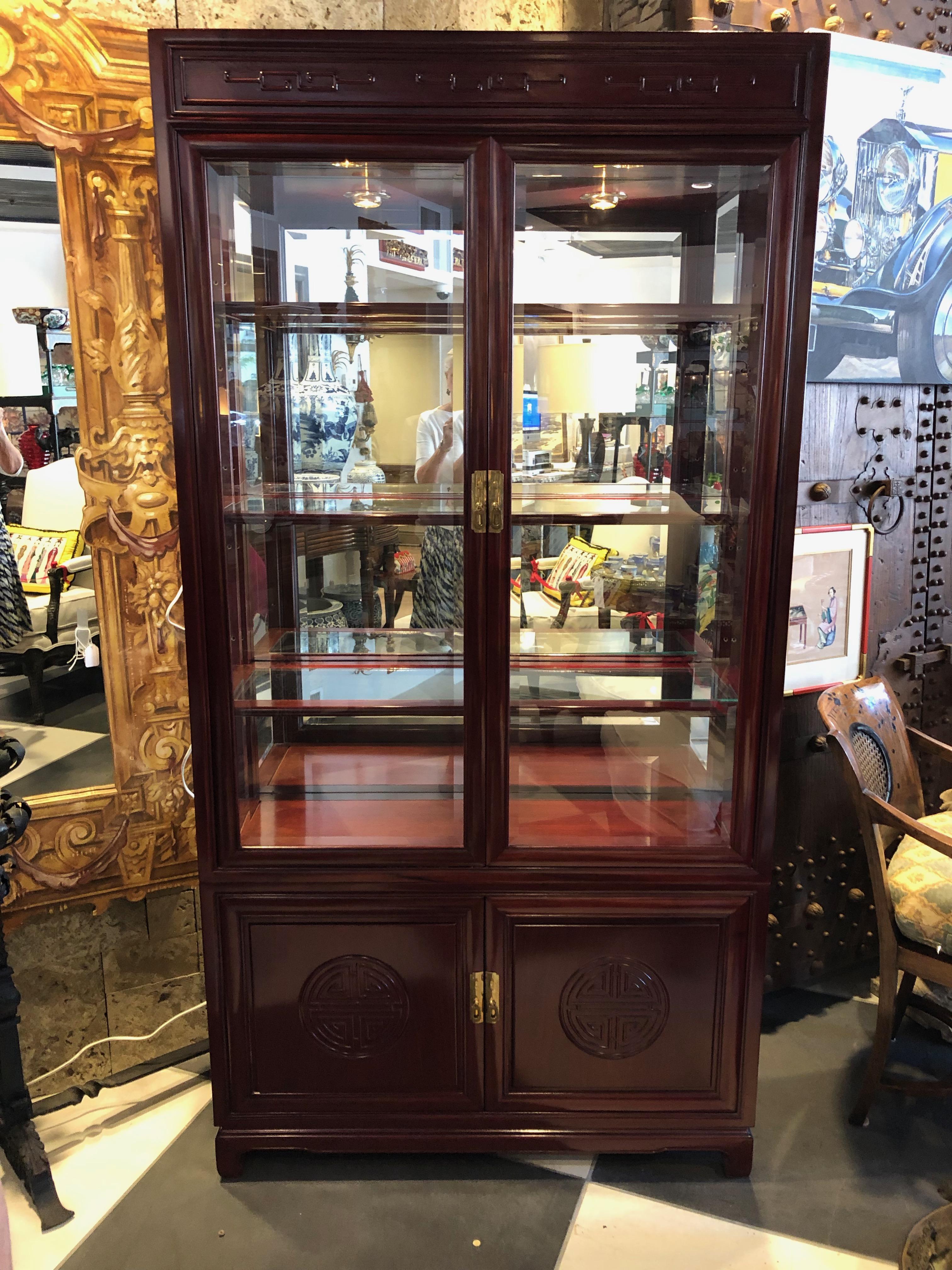 This pair of John Widdicomb has an Asian influence. Mahogany and glass with brass handles. The 3 glass shelves are trimmed in mahogany re- movable and adjustable. They are well made having a pair of glass doors trimmed in mahogany to the top and