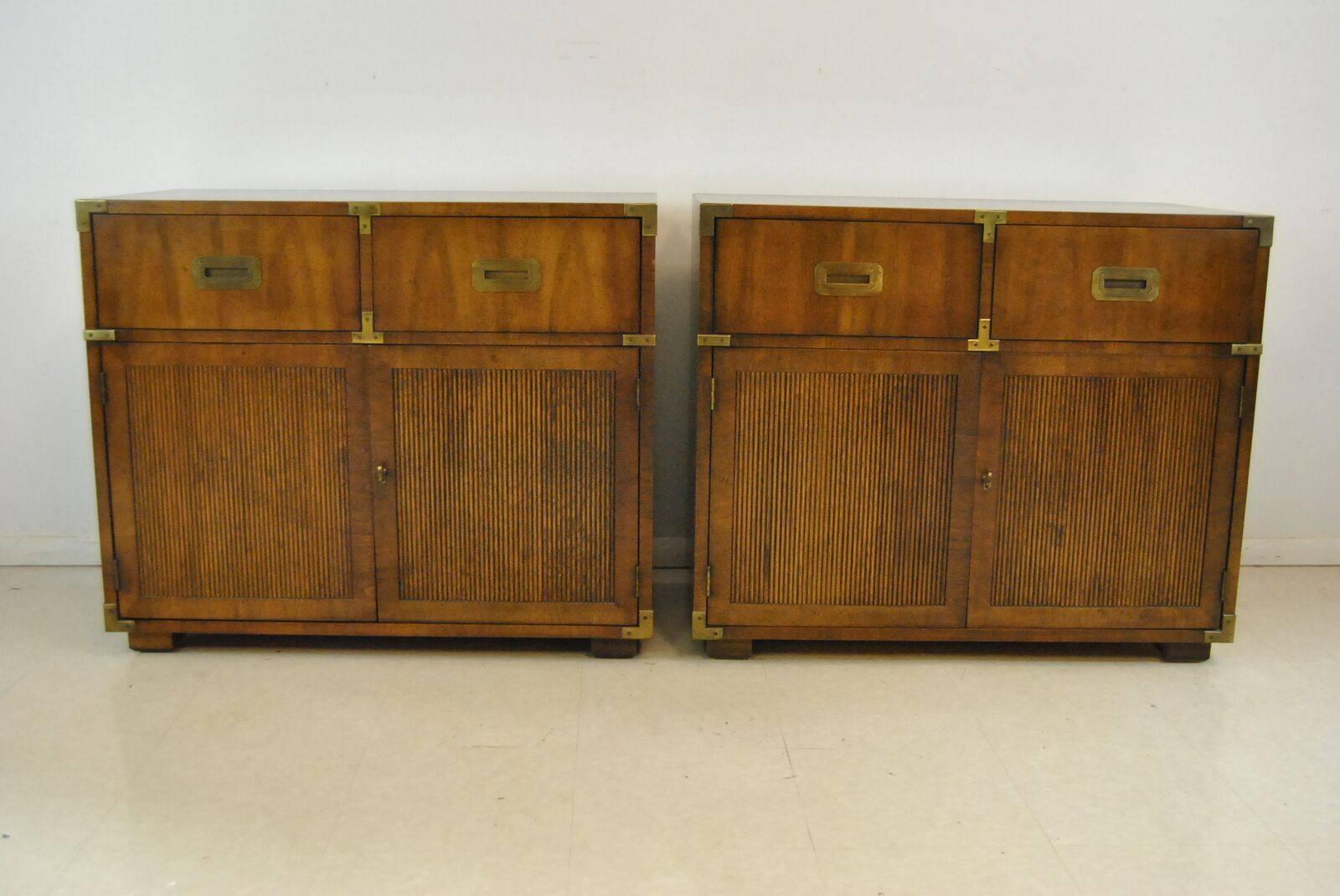 A nice pair of Henredon Campaign nightstands or small chests. They have the solid brass campaign hardware and are finished in a nice rich mahogany. They have two lower doors that open up to adjustable shelves on the interior. The lower doors have a