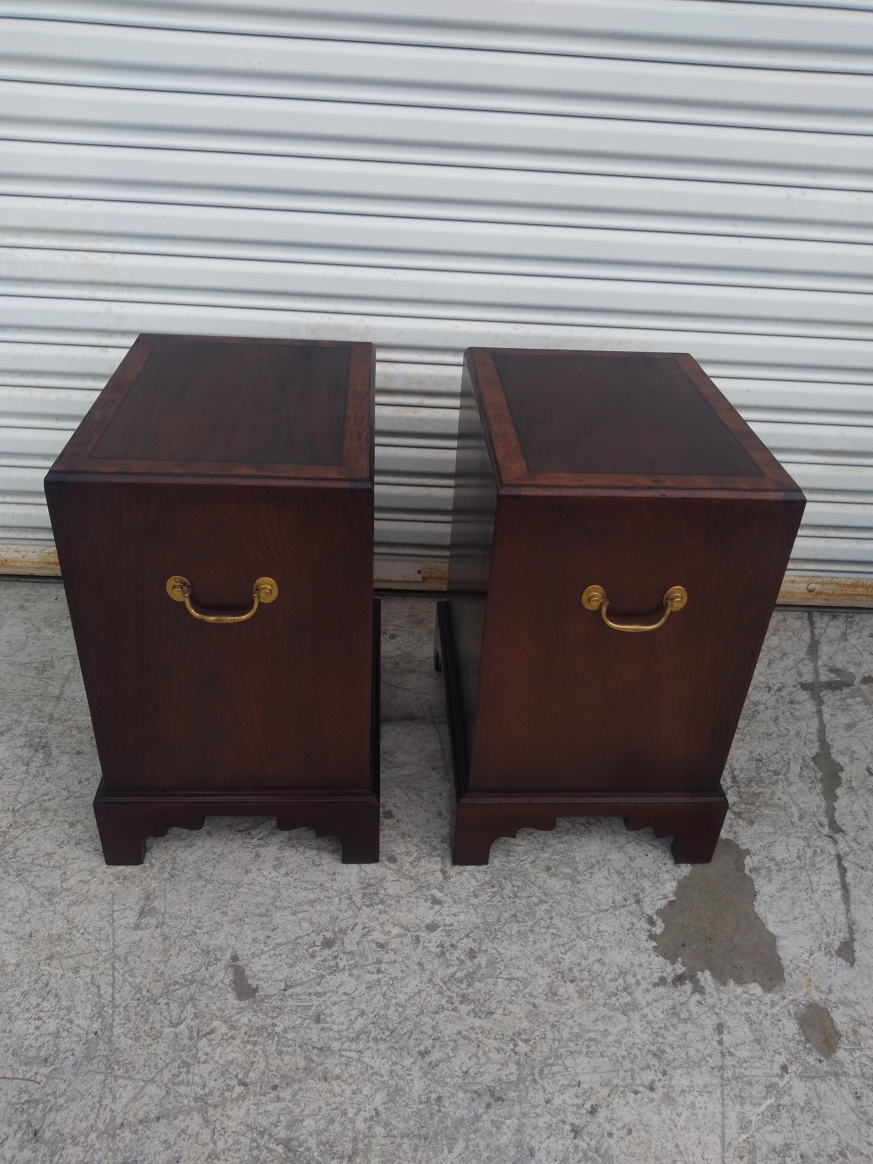 This is a wonderful pair of nightstands/end tables. They're made in the Chippendale style and have inlaid tops. The wood is a choice mahogany that's accented with beautiful brass Chippendale Style pulls. The sides also have these pulls for easy