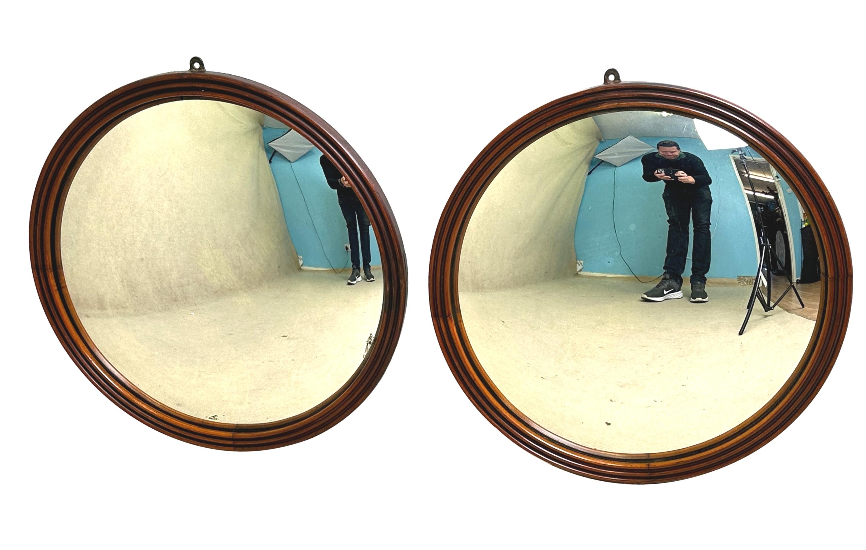 Paire de miroirs circulaires du milieu du XIXe siècle de très bonne qualité et rarement trouvés, présentant de manière inhabituelle des cadres en acajou attrayants avec une élégante décoration de cannelures, renfermant des plaques de miroir convexes
