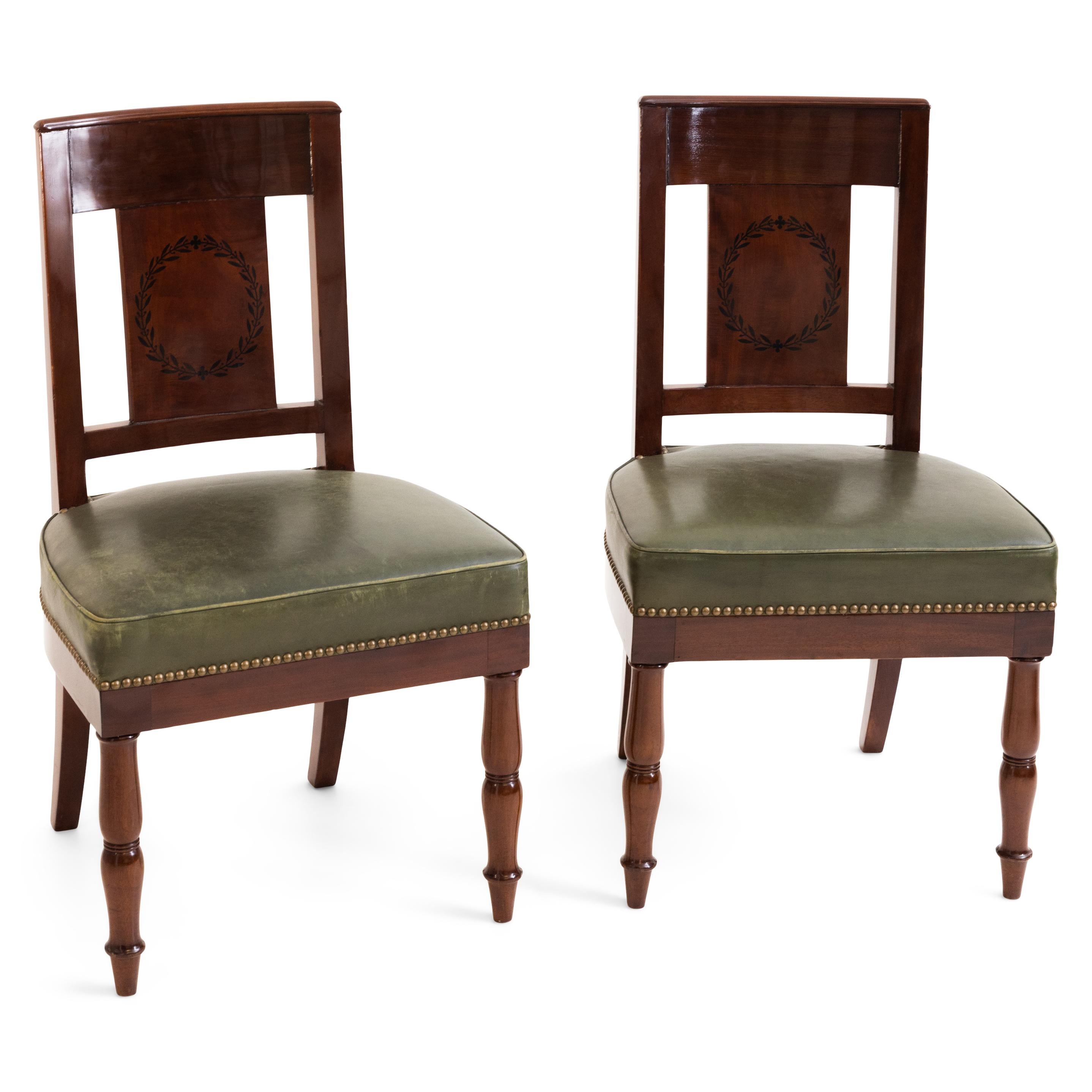 Pair of mahogany chairs circa 1810 on balustered front legs and slightly flared back legs. The backs each display a laurel wreath. Stamped Jacob D, R. Meslee.