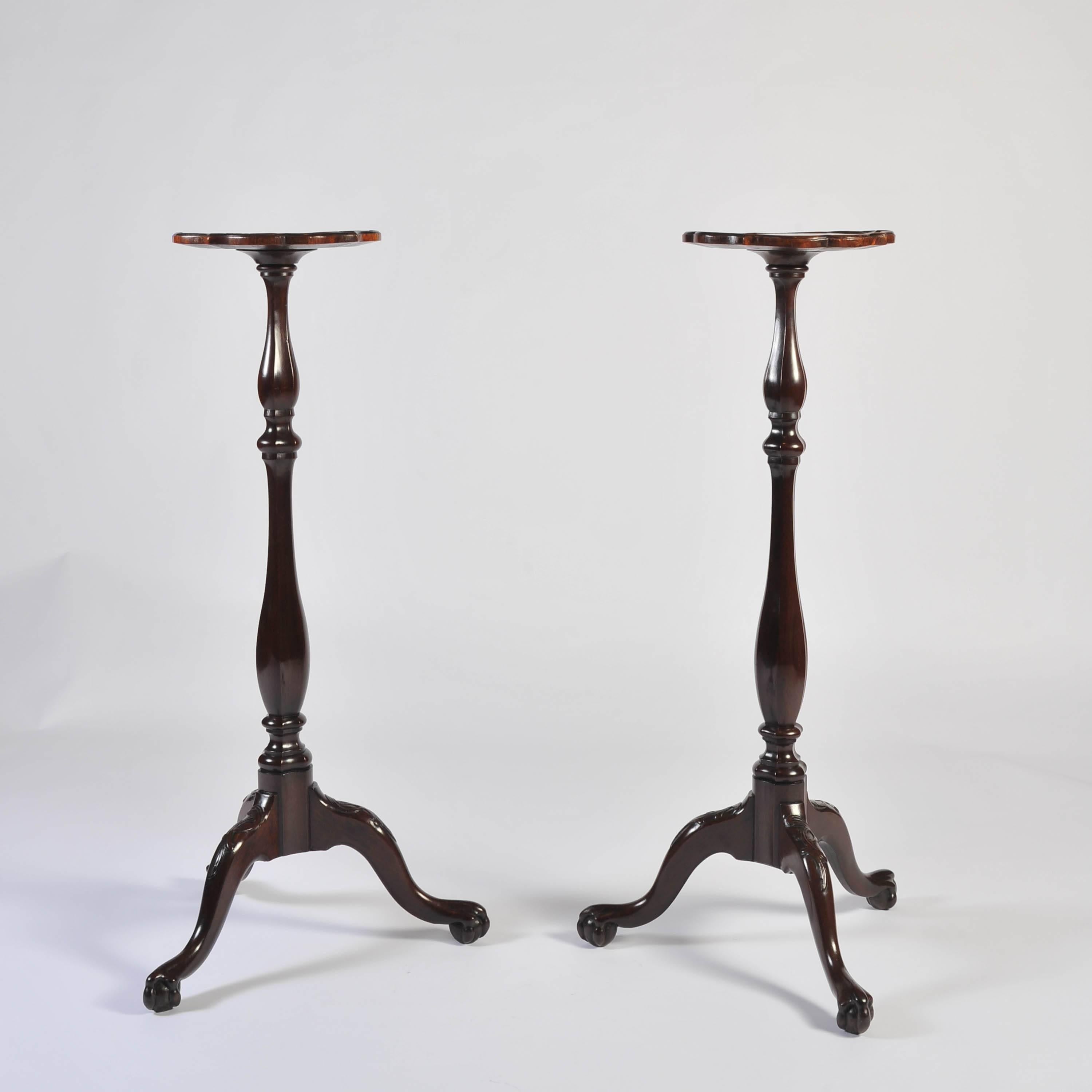 A fine pair of mid-18th century mahogany Dutch torcheres. The quatrefoil tops with moulded edge on double baluster shaped triform stems on a tripod base with cabriole legs carved at the knee, terminating and ball and claw feet. 
Wonderful color and
