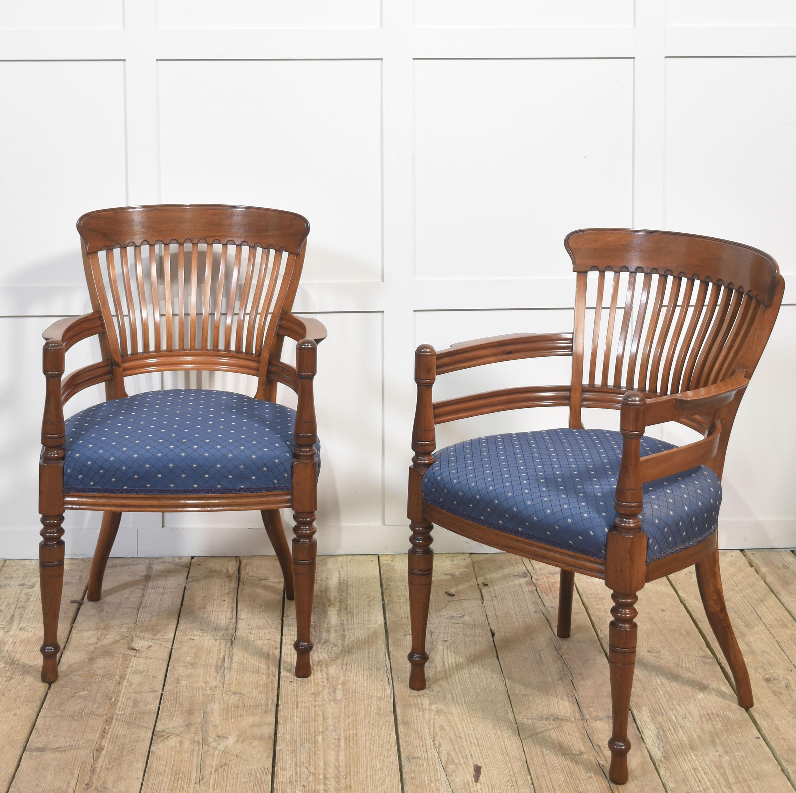 Une très belle paire de chaises coudées antiques en acajou, conçues à la manière de E.W. Godwin. Chaque chaise présente une traverse supérieure façonnée au-dessus d'un élégant dossier en fuseau incurvé, avec des accoudoirs évasés soutenus par des
