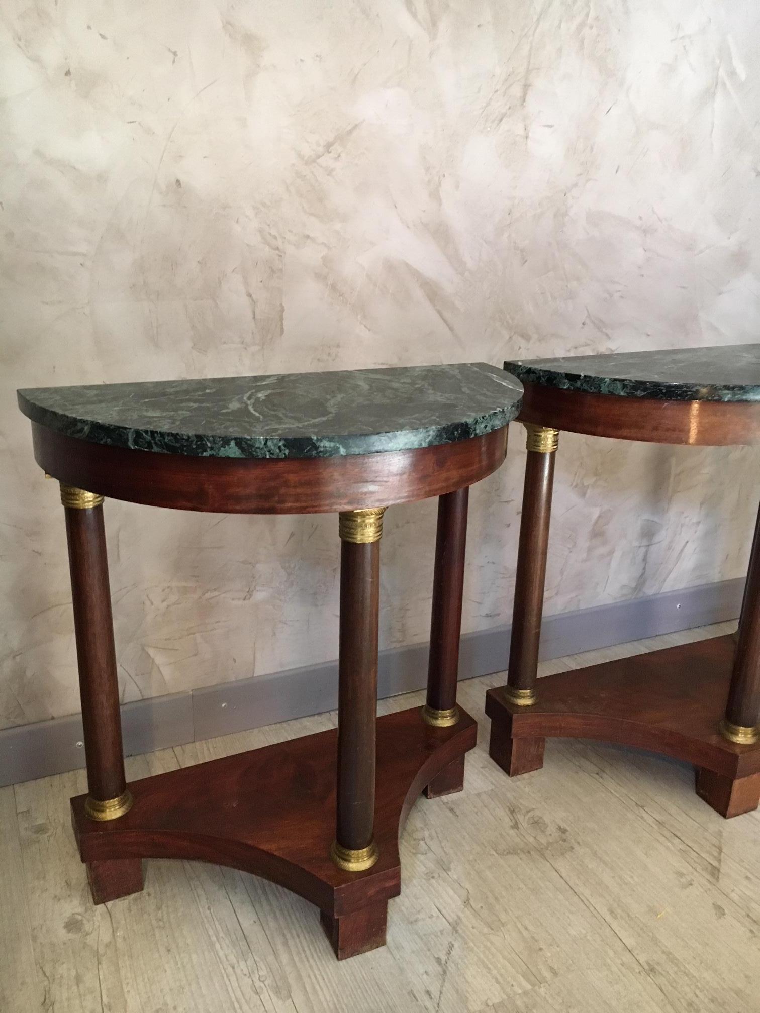 Very nice pair of mahogany Empire style half moon console table. Mahogany columns with brass ring at the extremities. Green marble top. When the two console table are reunited, it forms a round table.
These antique console tables type are pretty