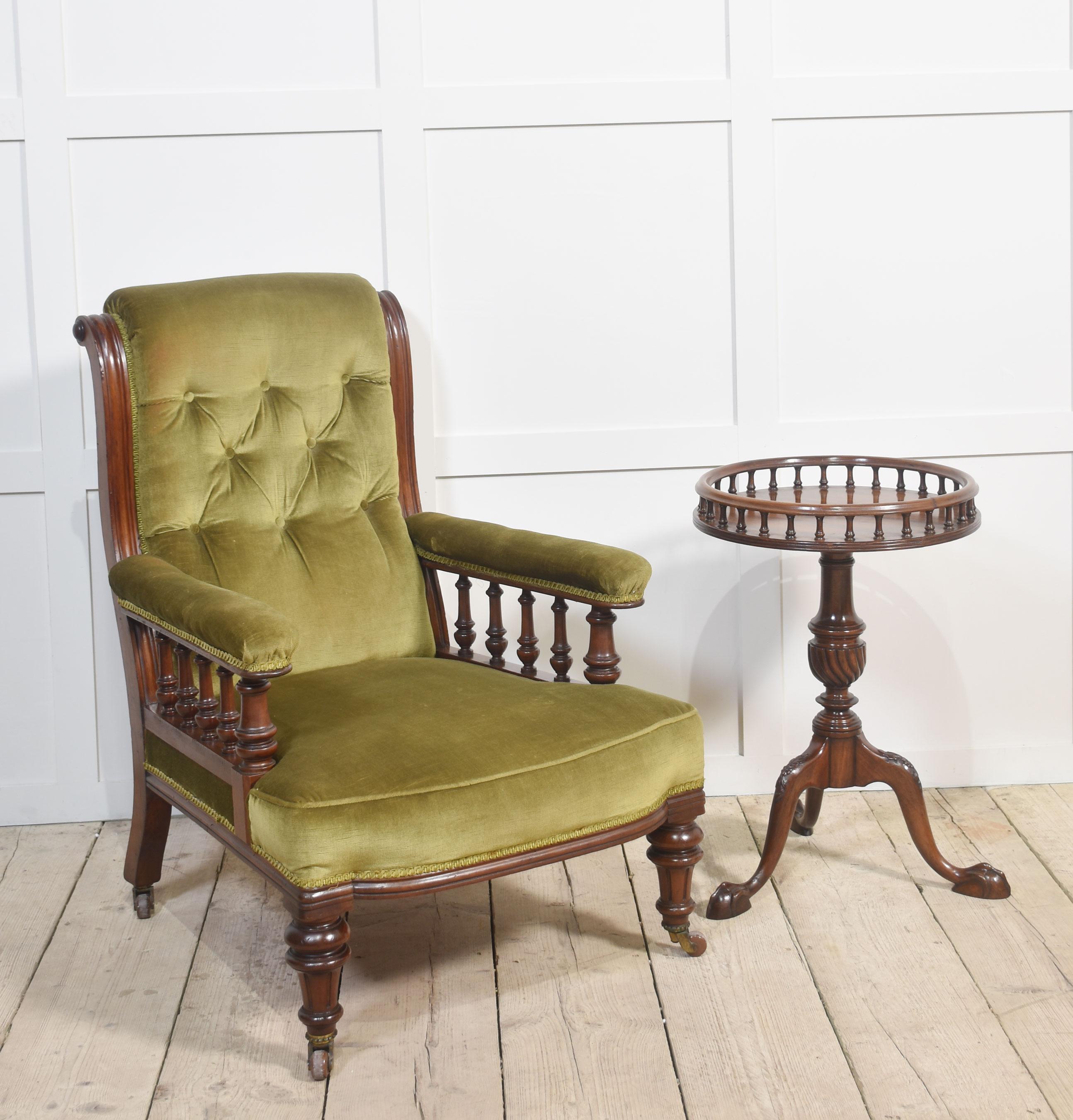 Paire de fauteuils de bibliothèque du XIXe siècle. Les chaises sont toutes tapissées en vert, avec des dossiers à boutons et des accoudoirs soutenus par des fuseaux tournés. Le tout repose sur des pieds tournés en acajou terminés par des