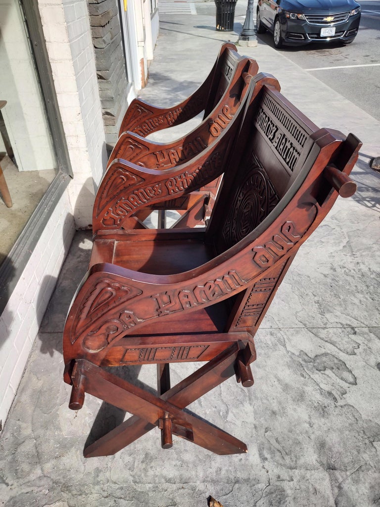 Fabulous pair of richly carved Glastonbury armchairs in Mahogany. Bold inscriptions adorn both sides of the arms and the inside back of both chairs. Along with the inscription are Celtic Symbols. All hand pegged and can be disassembled easily. Very