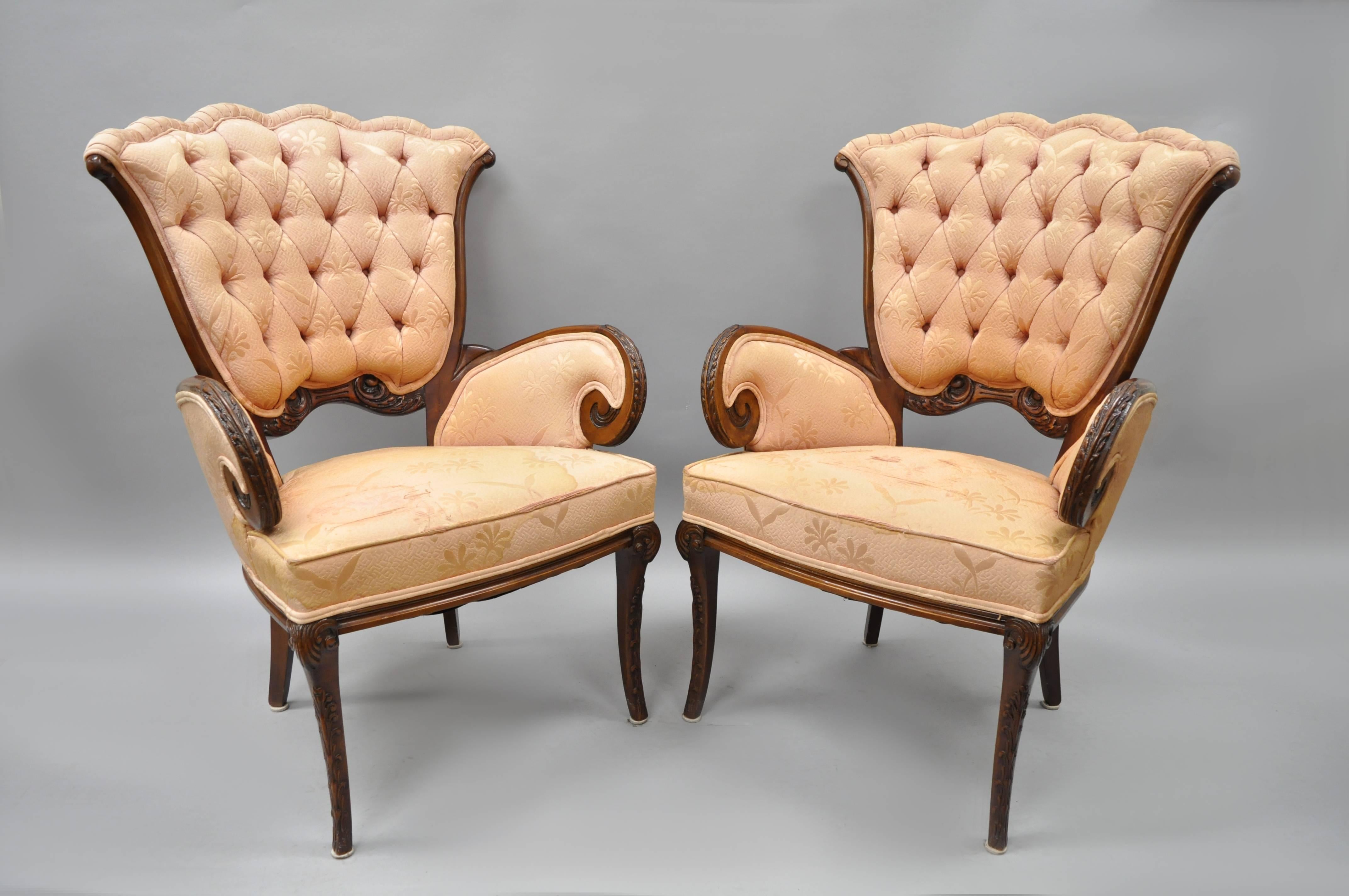 Pair of antique mahogany Hollywood Regency tufted armchairs attributed to Grosfeld House in the Dorothy Draper style. Chairs feature solid carved mahogany wood frames, scrolling arms, tapered saber legs, tufted upholstery, and remarkable quality and