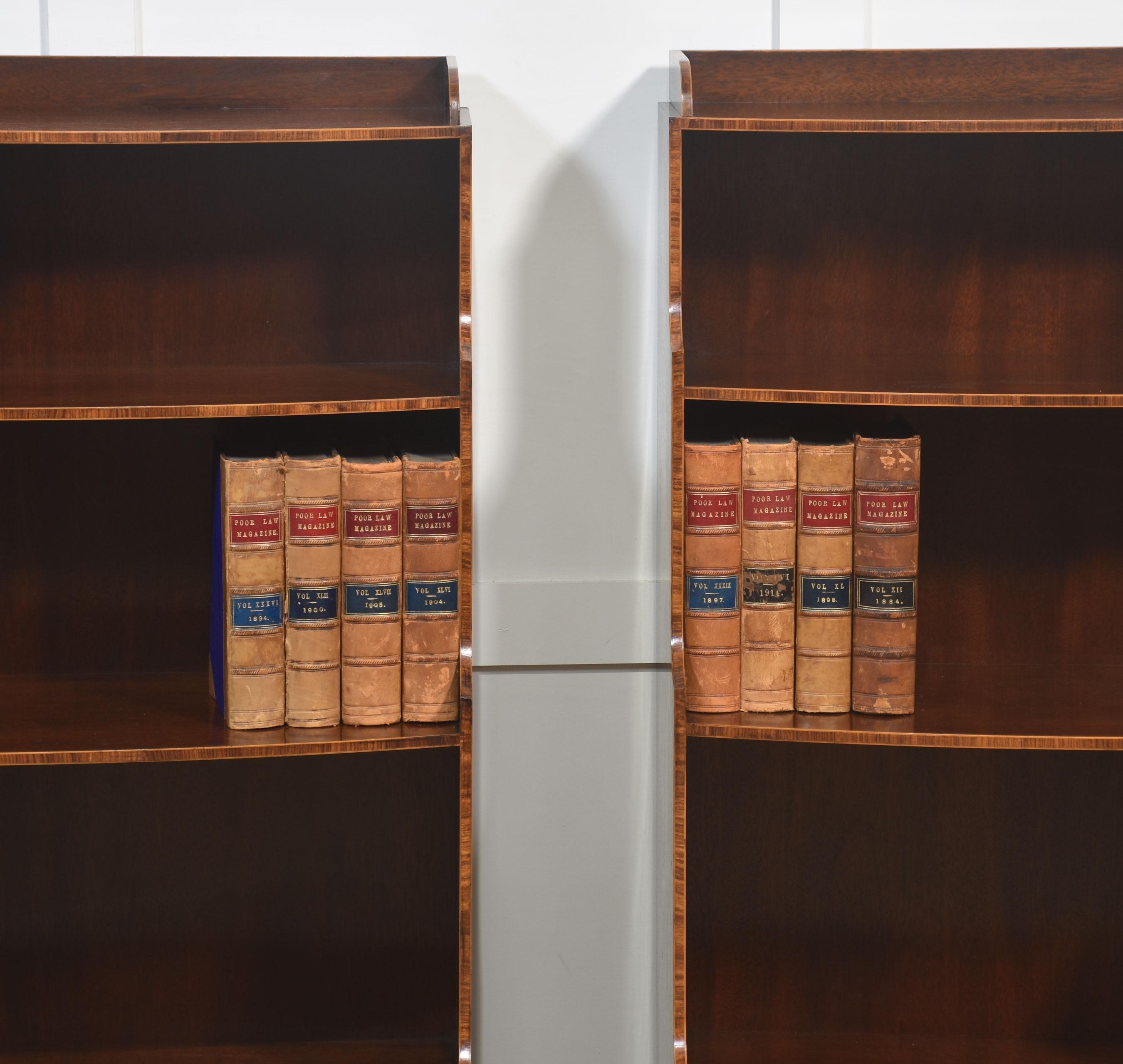 Una bella coppia di librerie a cascata in mogano. Ogni pezzo è composto da tre ripiani aperti graduati, con i lati delicatamente sagomati nel classico stile a cascata, sopra un cassetto ad arco dotato di maniglie ad anello in ottone. Il ricco mogano
