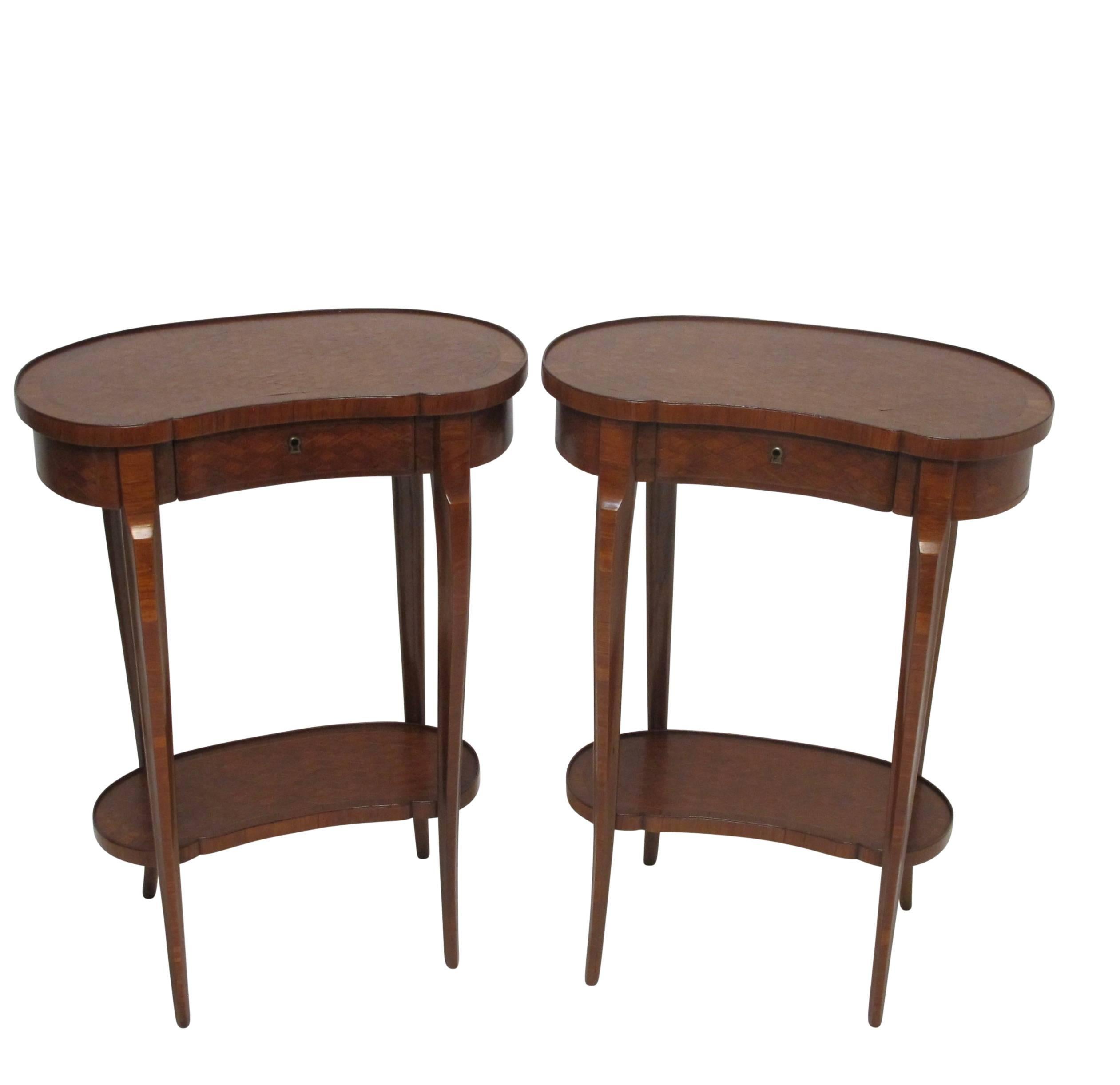 A pair of charming mahogany side tables with inlaid parquetry design, having a single drawer, a lower shelf, and standing on cabriole legs. France, circa 1900.