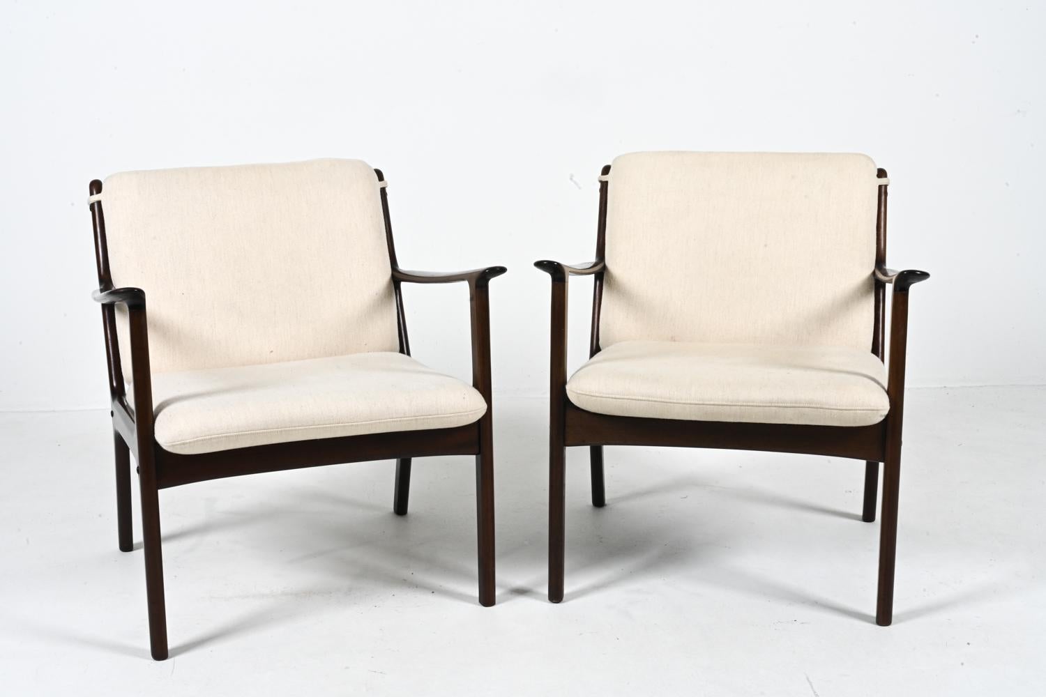 Elevate your living space with this exquisite pair of PJ 112 lounge chairs, a timeless creation by the visionary Ole Wanscher for Poul Jeppesen. Crafted from rich mahogany, the frames of these chairs exude a warm, inviting allure, while the