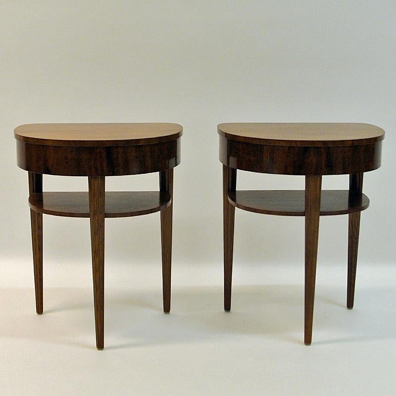 Beautiful pair of mahogany tree night tables from Bodafors, 1940s. The tables have a small shelf underneath held up by three elegant legs with decorative stripes carved into the wood in parallel patterns. Surface is rounded with no sharp edges and