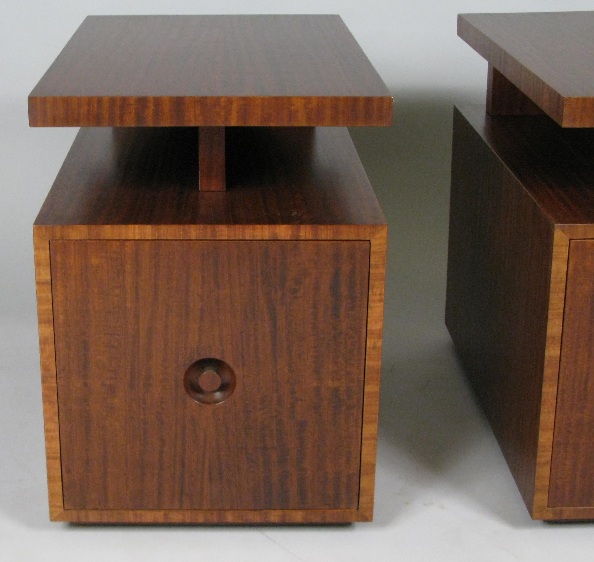 A very handsome pair of late 1940s mahogany nightstands by Andrew Szoeke. designed with a floating top with recessed storage underneath, and a single door concealing an adjustable shelf in the cabinet below. Beautiful wood grain, and each door has a